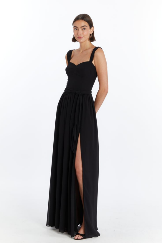 Girl in long black maxi dress with slit, side facing. view 2