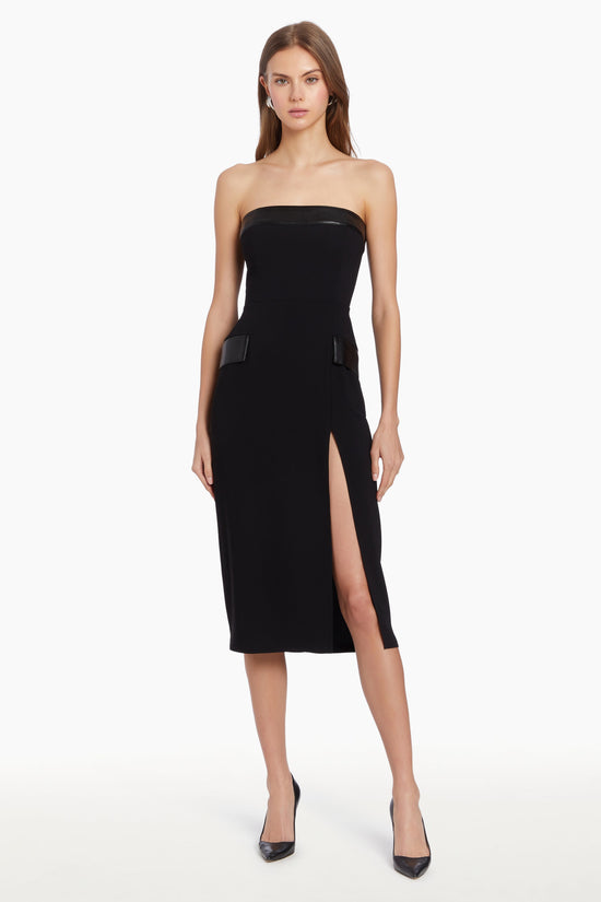 Girl in black midi dress with leather details and slit, front facing. view 1