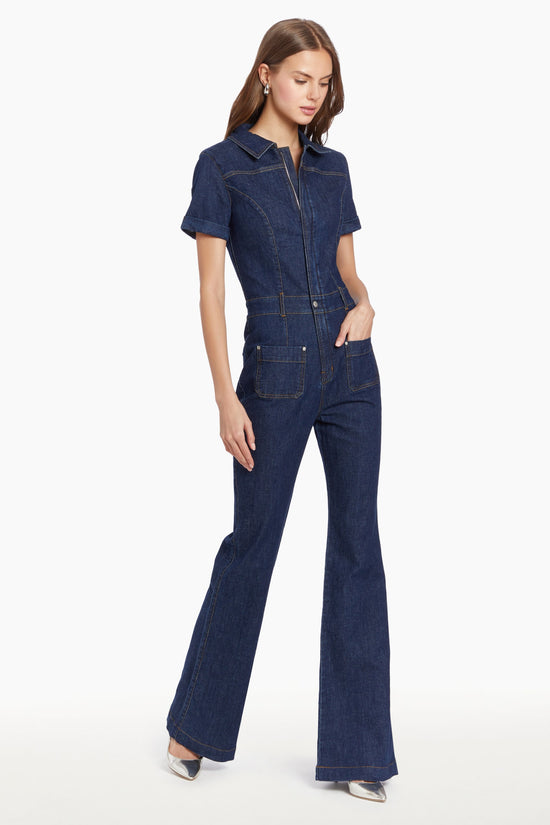 Girl in denim jumpsuit, side facing. view 2