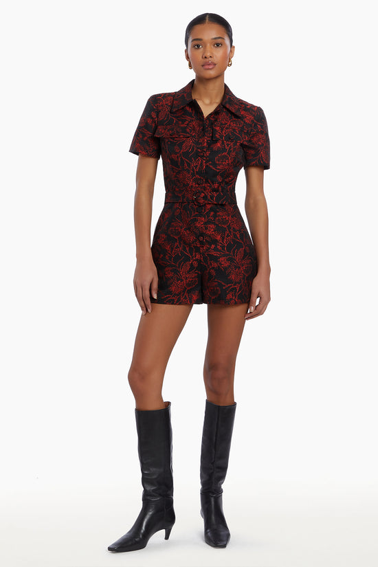 Girl in black and red floral romper, front facing. view 1