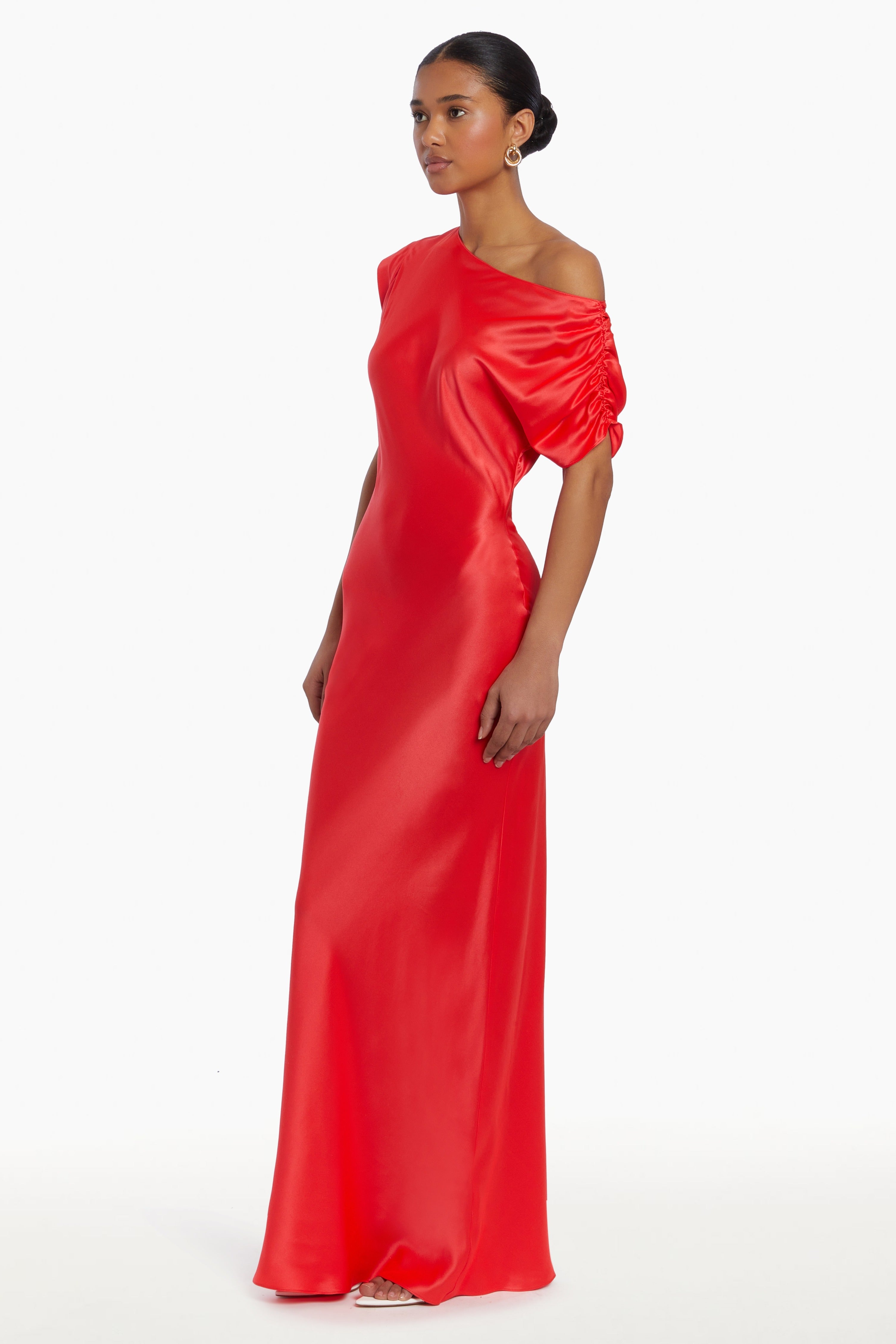 Girl in silk one shoulder red maxi dress, side facing.