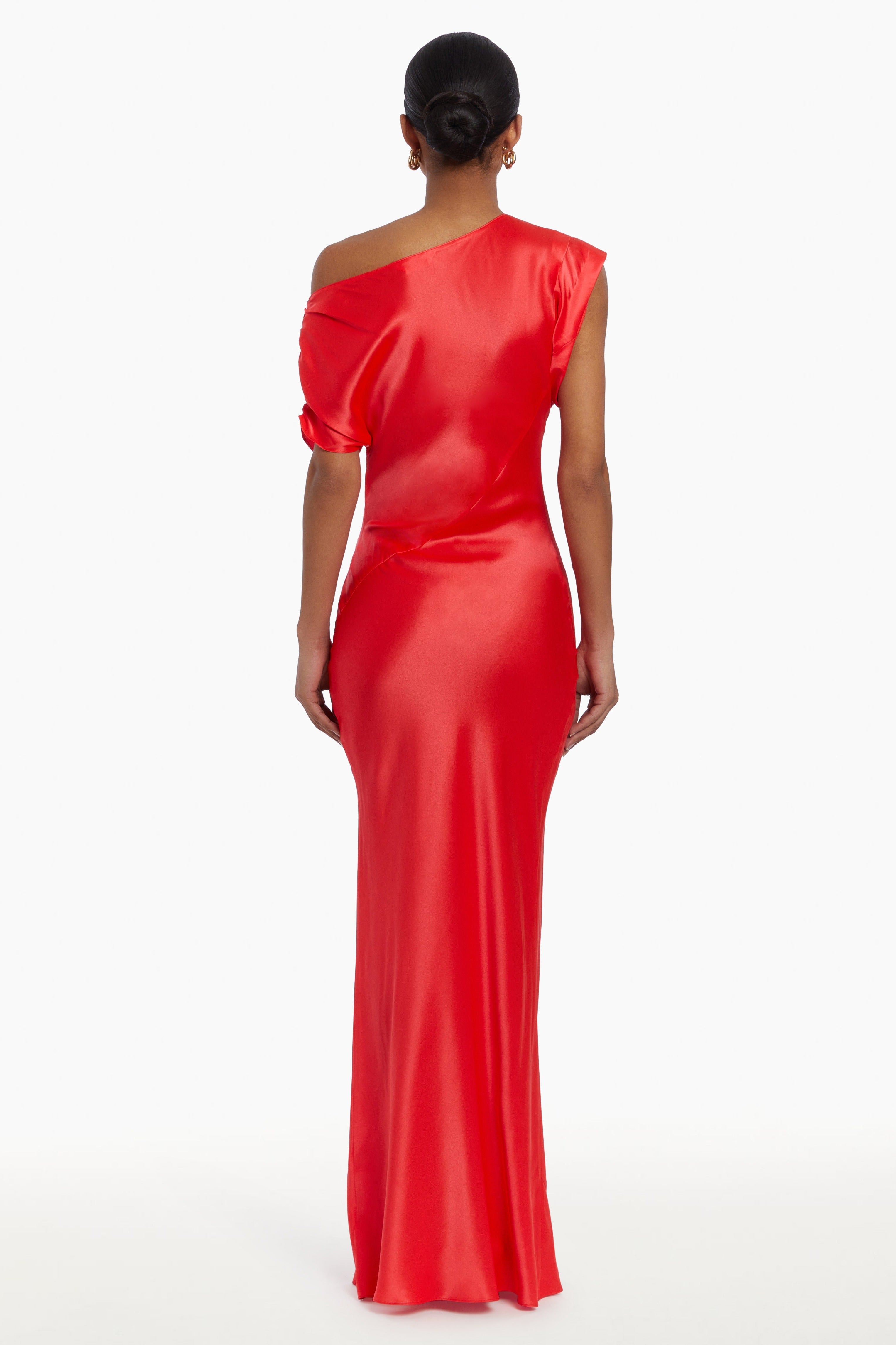 Girl in silk one shoulder red maxi dress, back facing.