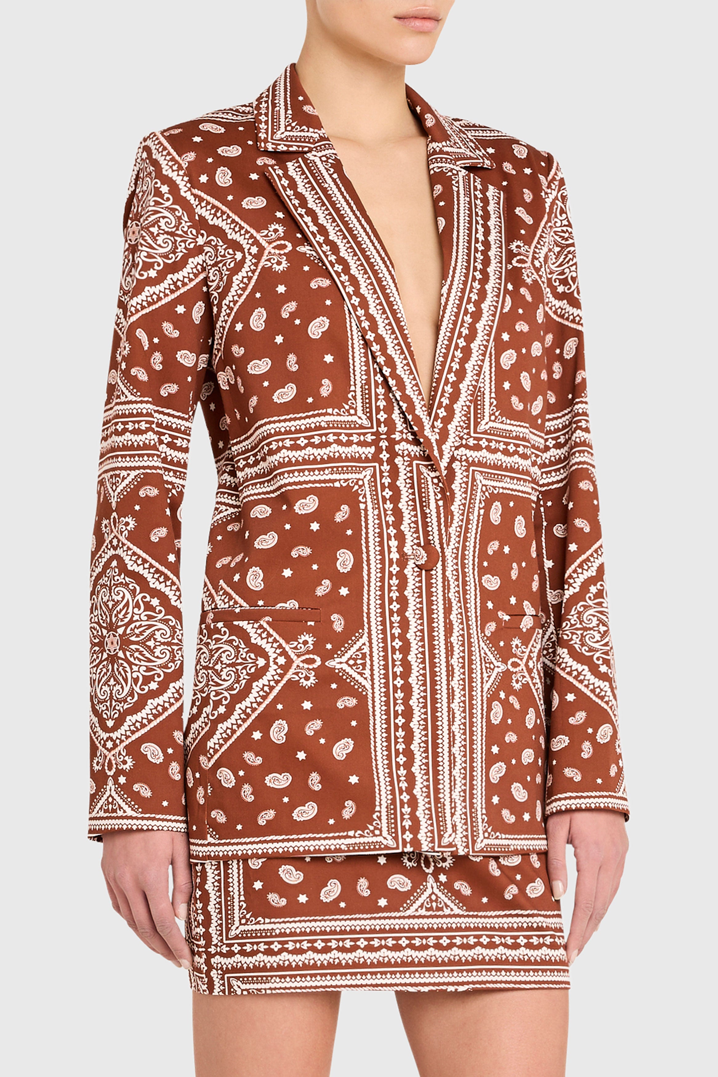 Brown patterned dress worn by a person on a white background