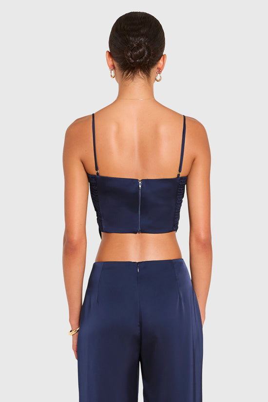 Amanda Uprichard | Juna Top in Ink Blue. Model wears a blue top against a white backgorund. view 3