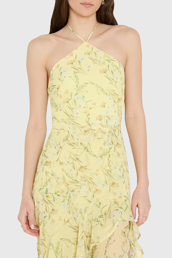 Woman wearing a yellow floral dress against a white background
