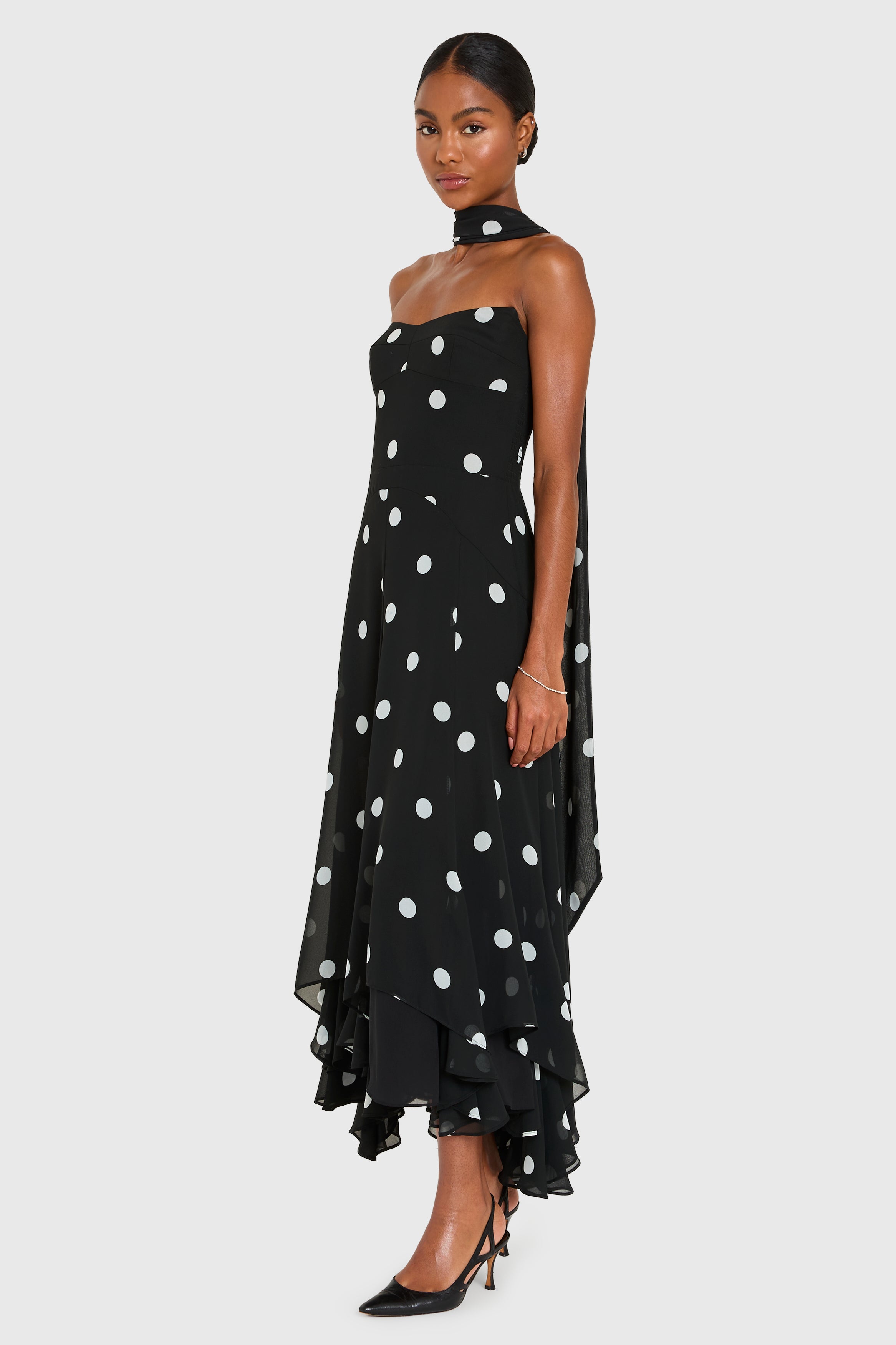 Woman wearing a black polka dot dress on a white background