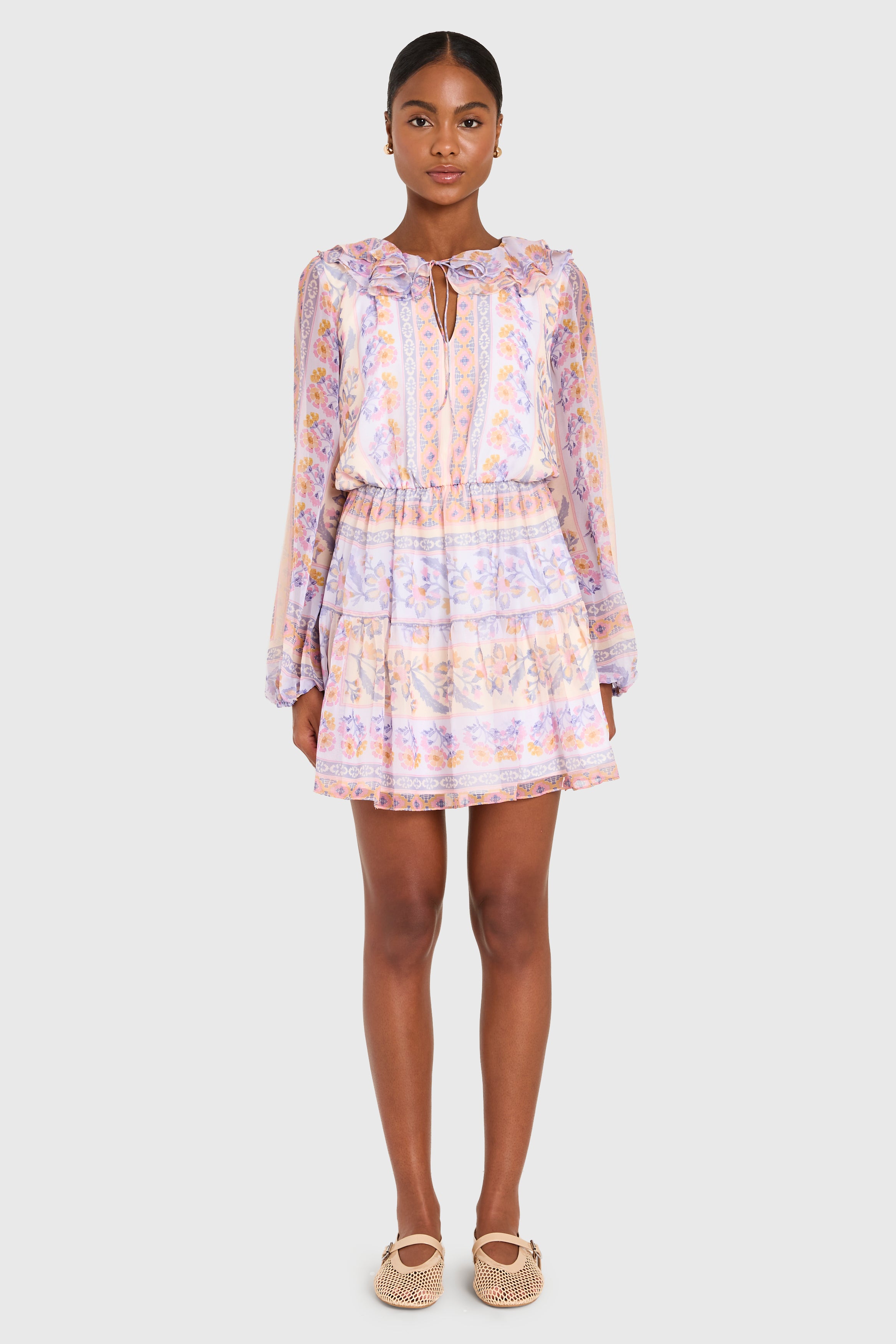 Woman wearing a patterned dress on a white background