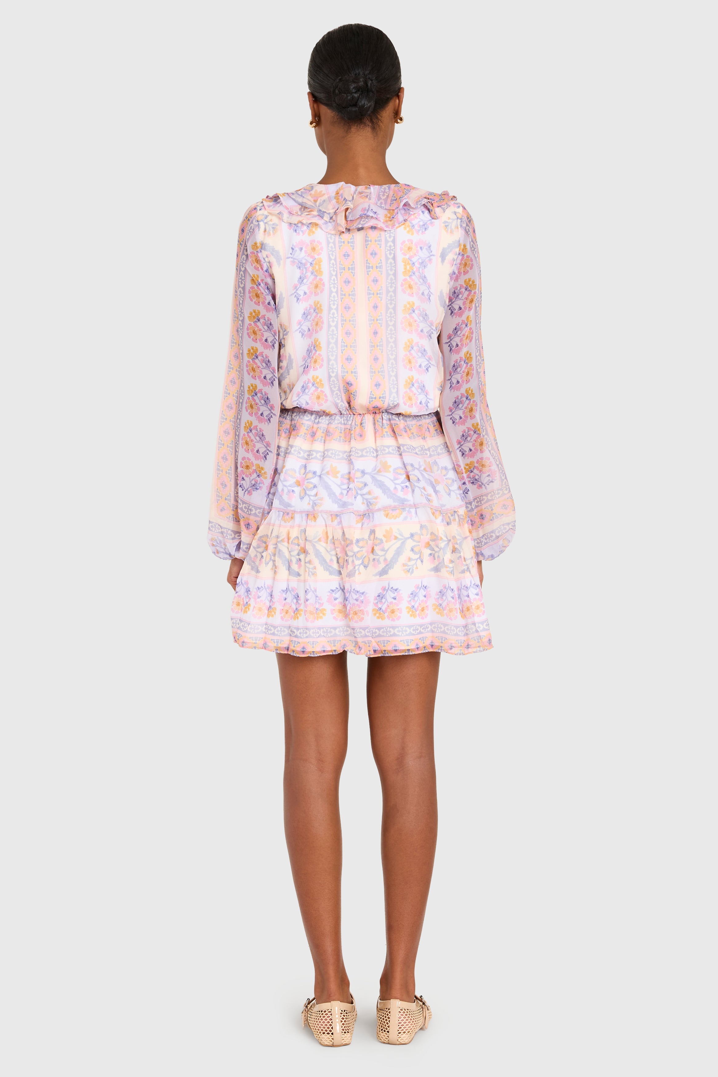 Person wearing a patterned dress on a white background