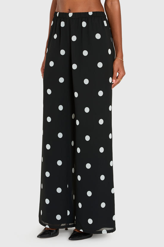 Black wide-leg pants with white polka dots worn by a person on a white background view 2