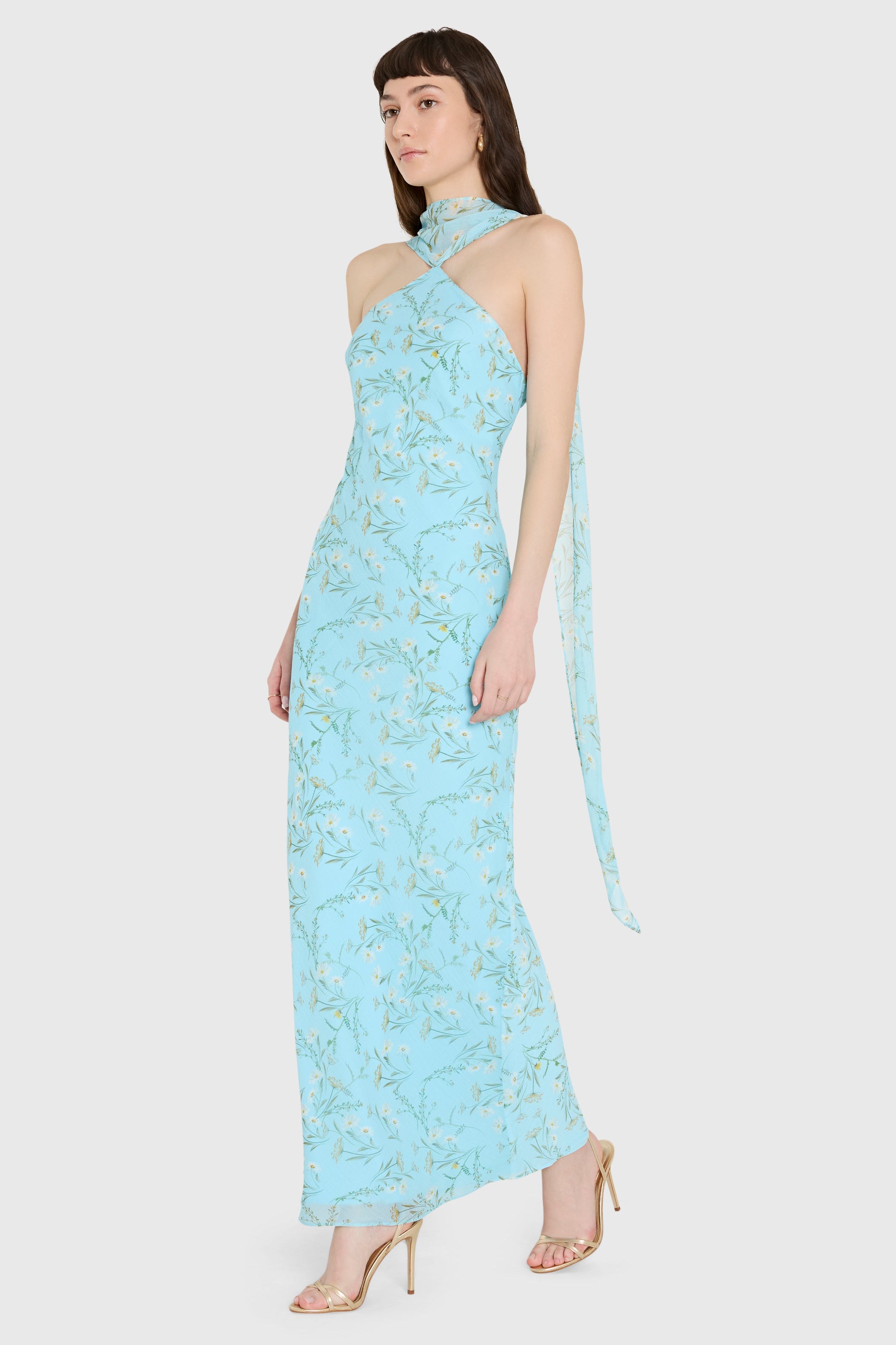 Woman wearing a light blue floral dress on a white background