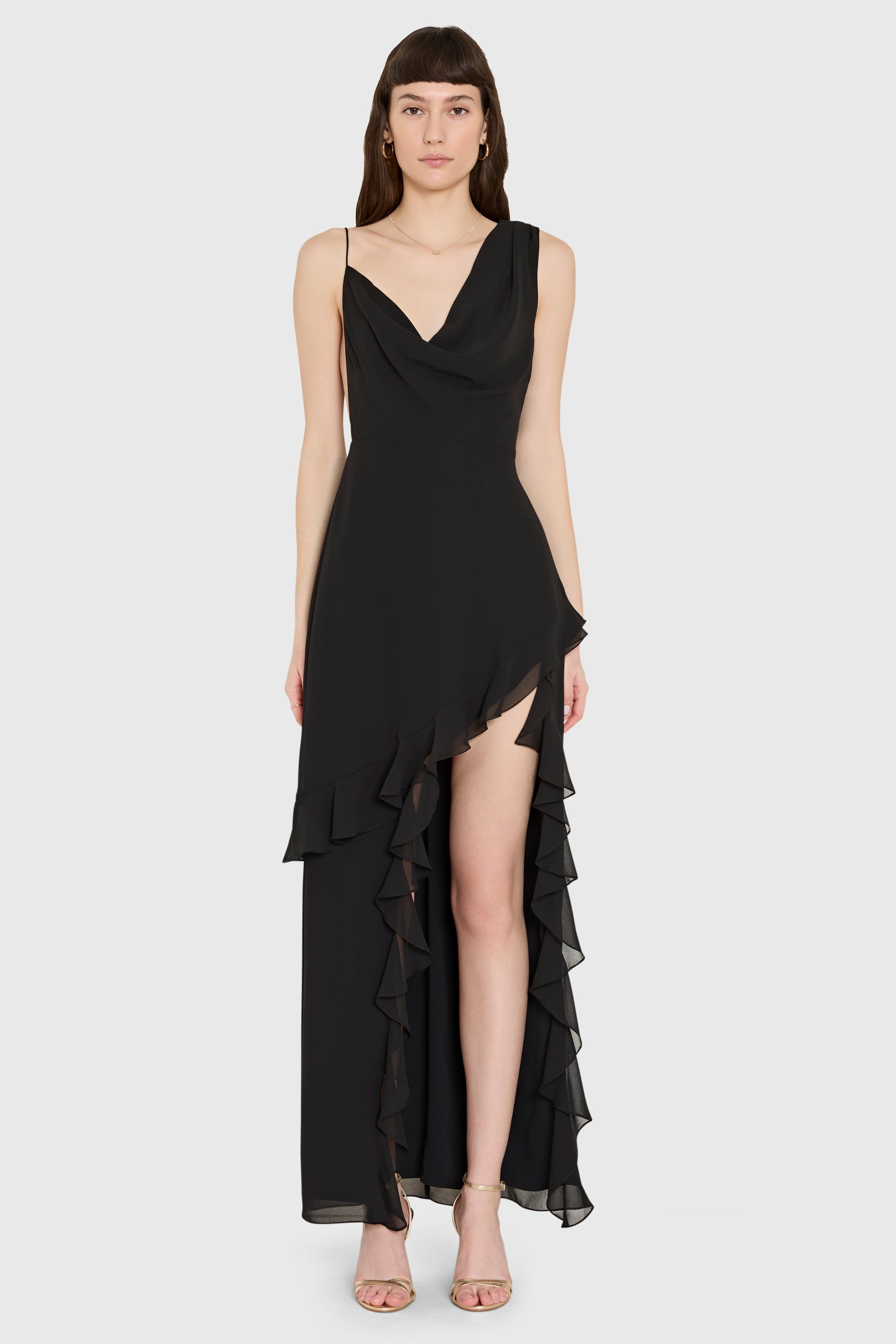 Black dress with ruffled layers worn by a model on a white background