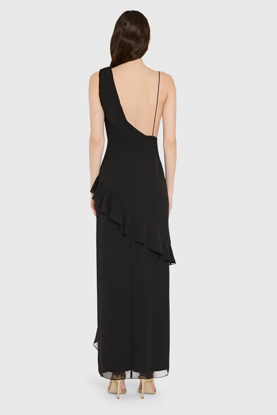 Black dress with one wide strap and one spaghetti strap from the back on a white background