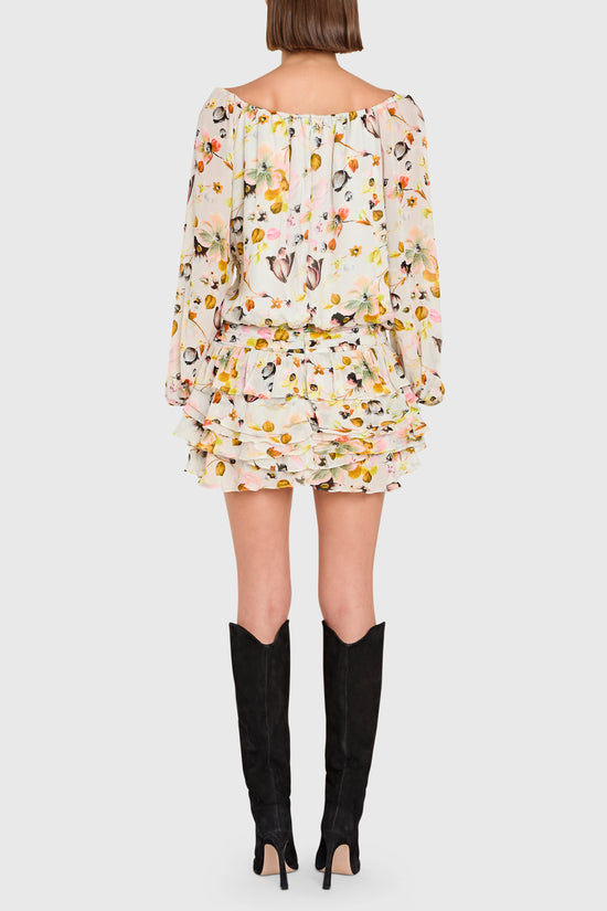 Person wearing a floral dress with long sleeves and knee-high black boots on a white background