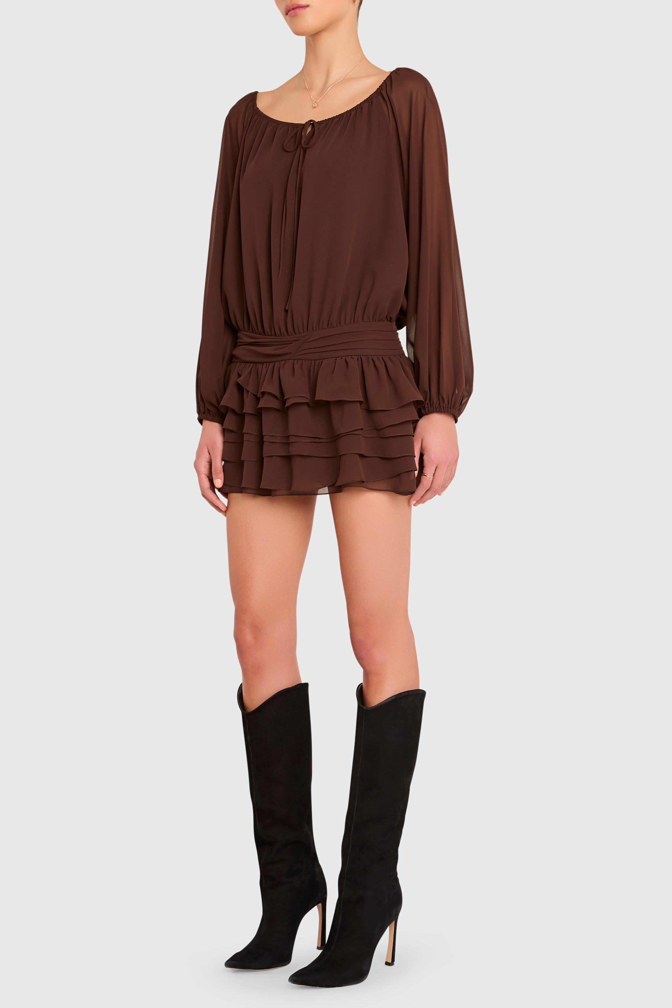 Brown dress with ruffled layers worn by a person on a white background