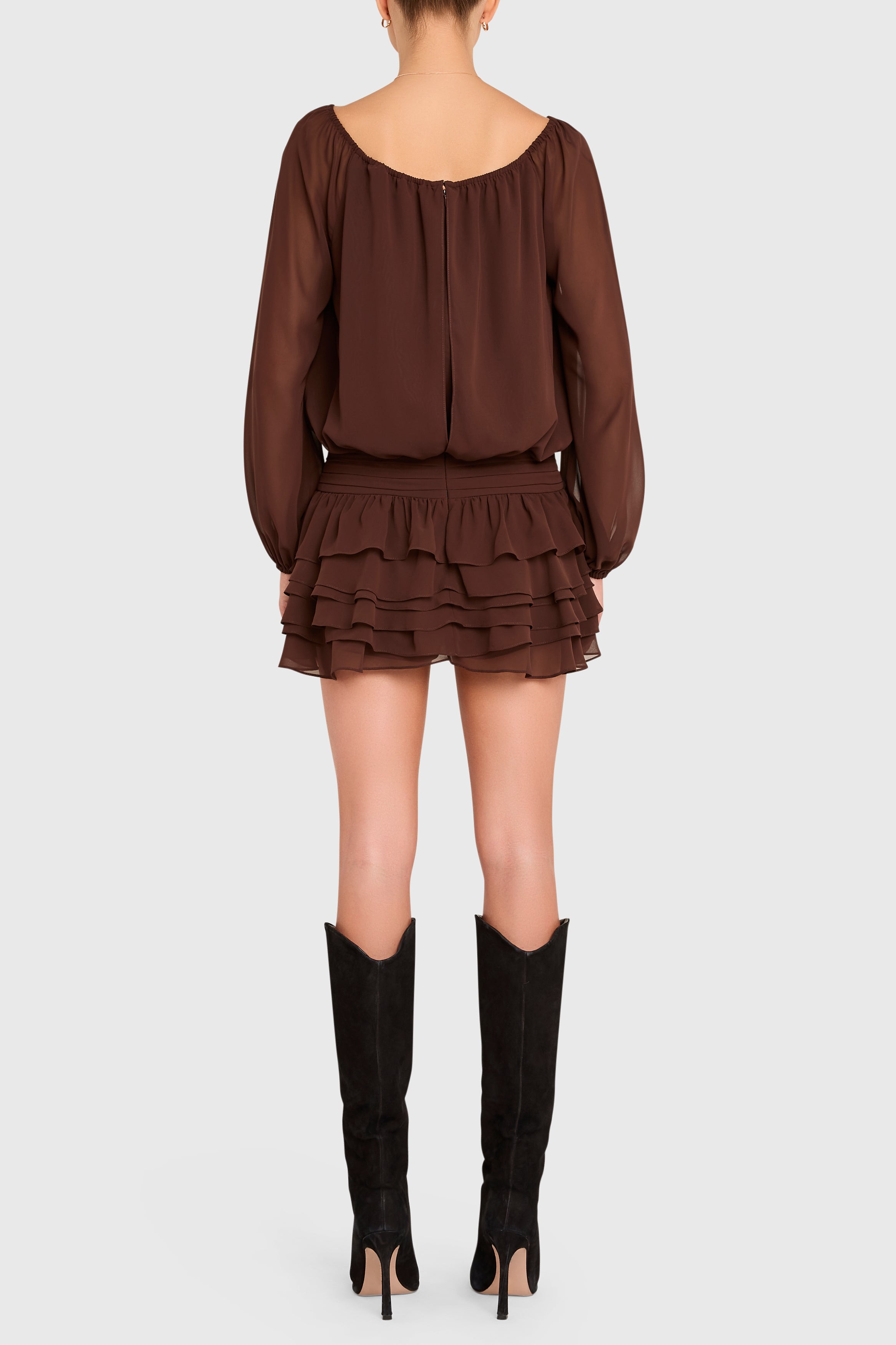 Brown ruffled dress with long sleeves and black knee-high boots on a white background