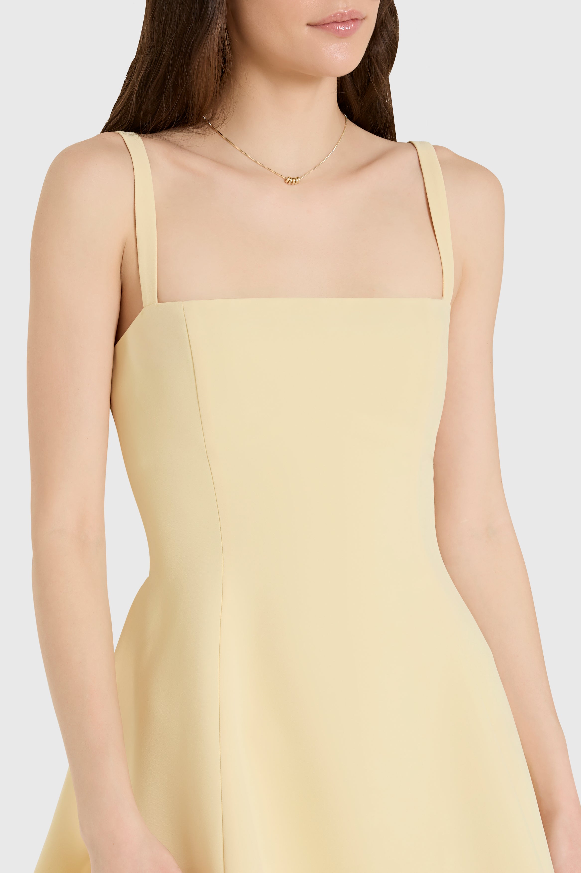 Yellow dress worn by a model on a white background