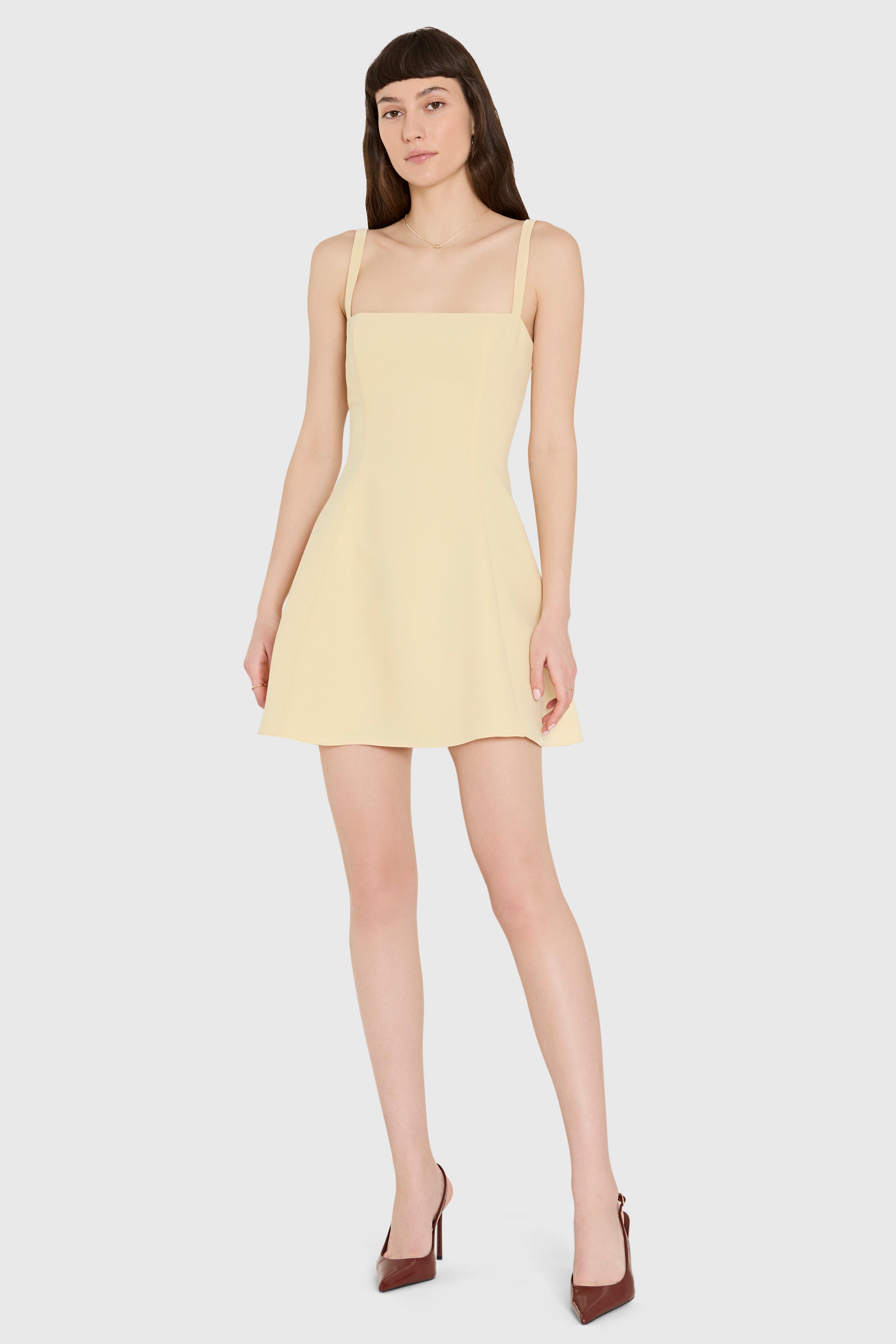 Woman wearing a light yellow dress on a white background