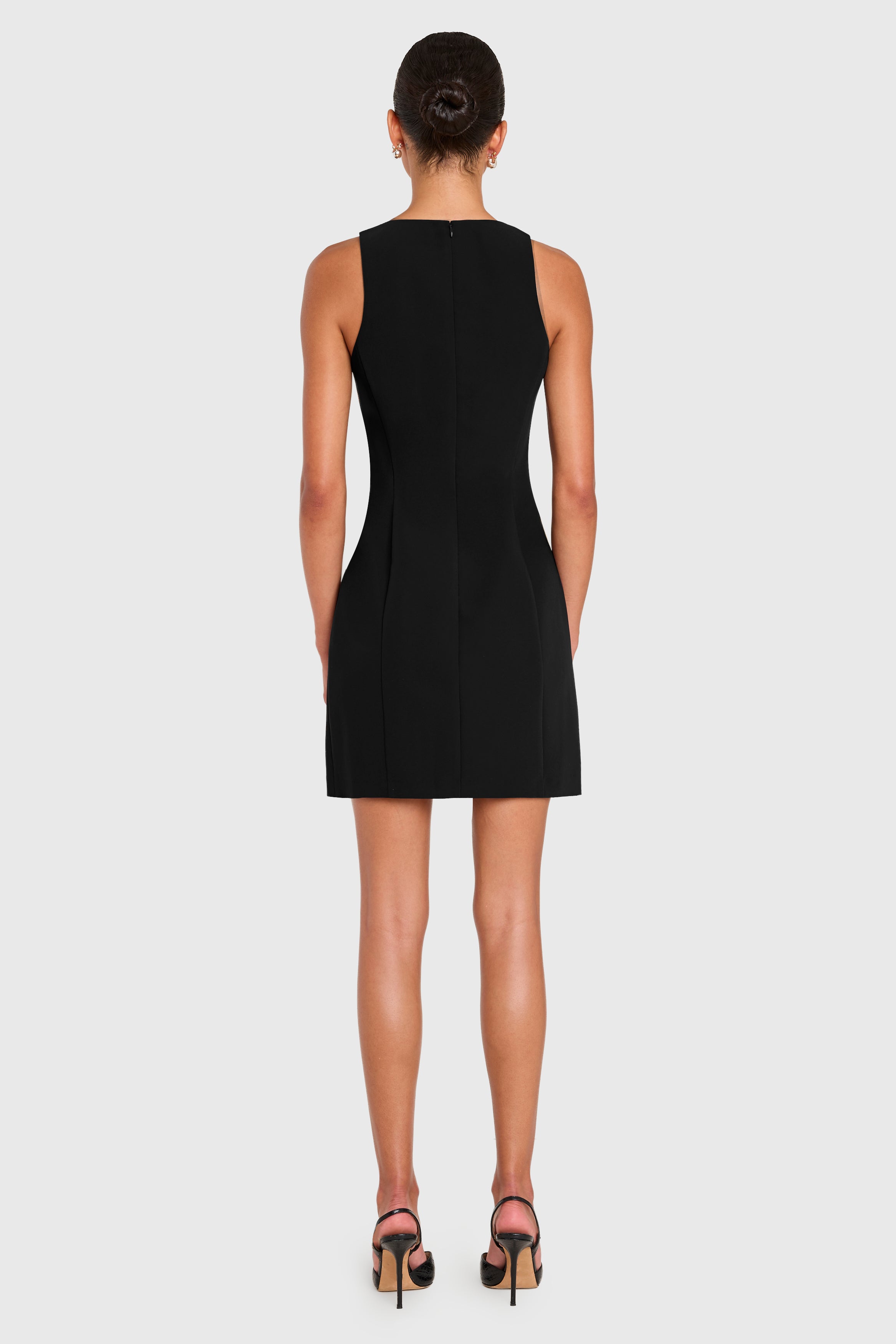 Black sleeveless dress worn by a model on a white background