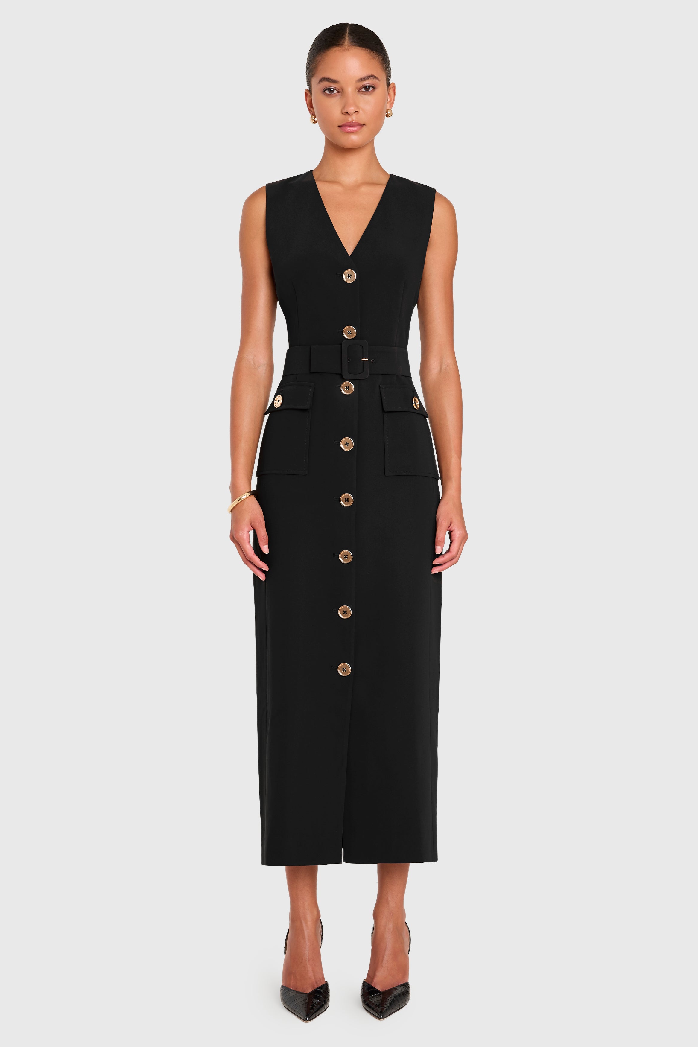 Woman wearing a black dress with buttons on a white background