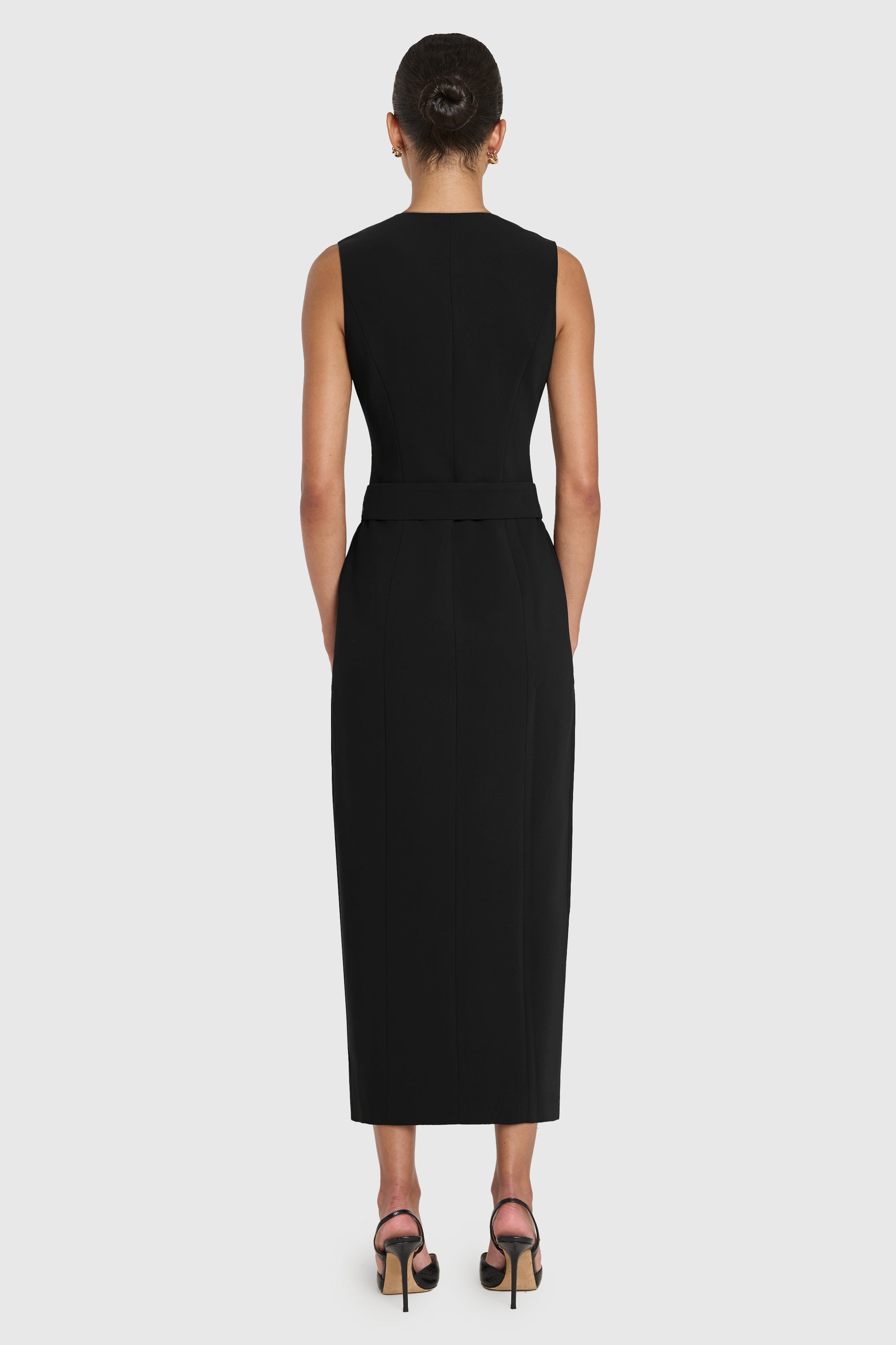 Black sleeveless dress worn by a person on a white background