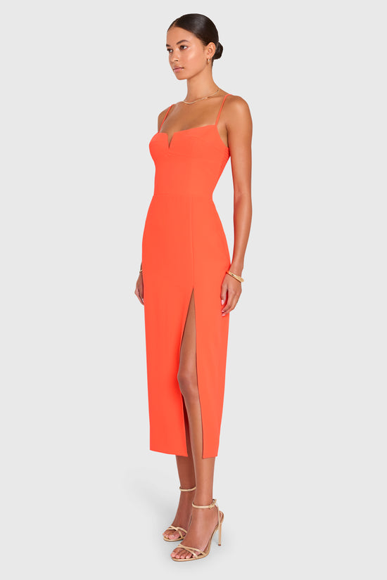 Amanda Uprichard |   Lyra Midi Dress in Serrano. Model wears an orange midi dress against a white backgorund. view 3
