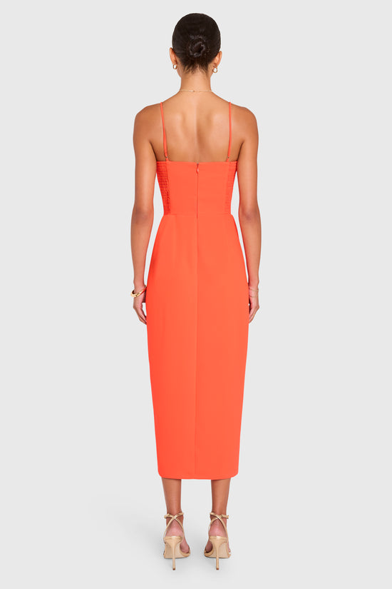 Amanda Uprichard |   Lyra Midi Dress in Serrano. Model wears an orange midi dress against a white backgorund. view 3