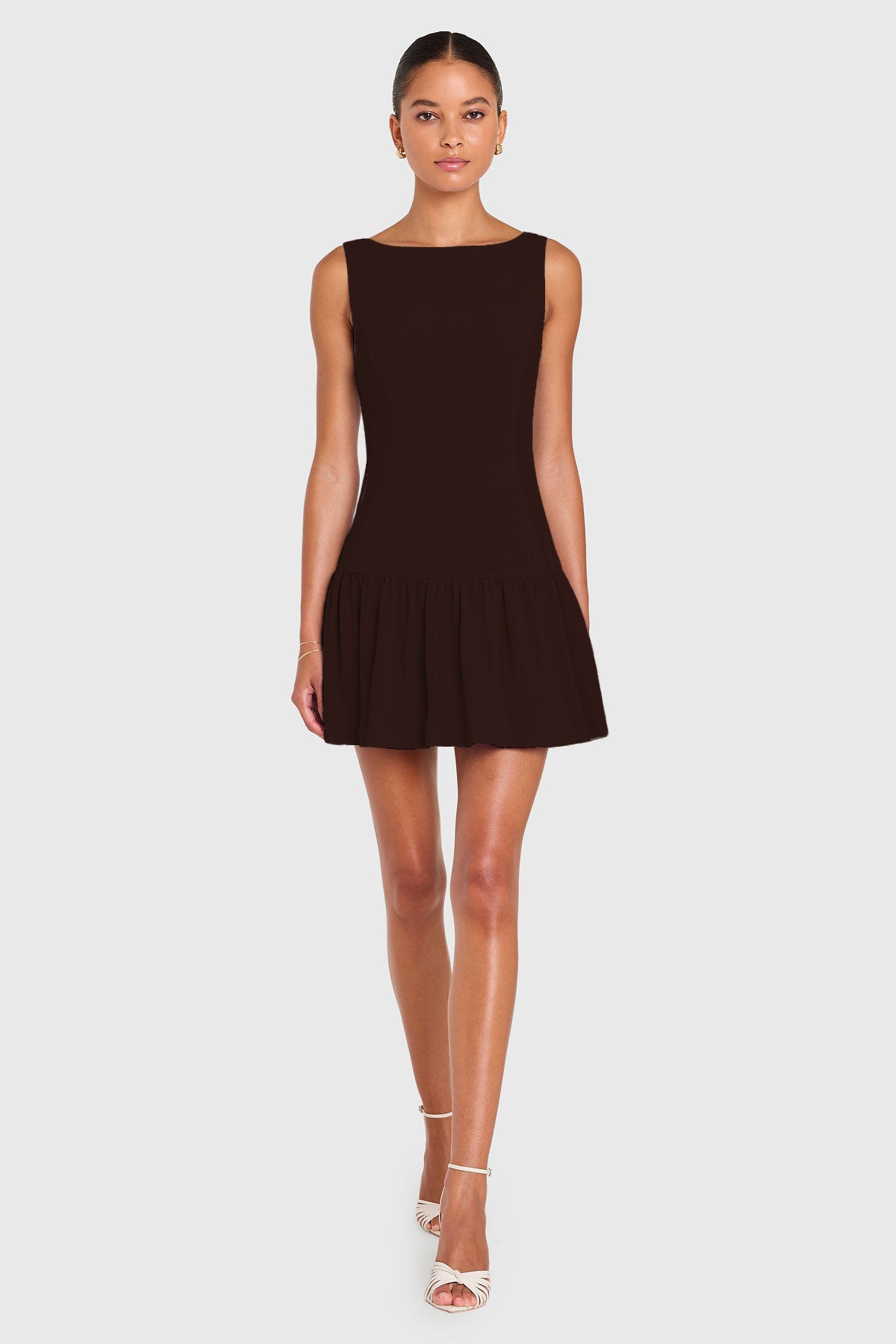 Woman wearing a brown sleeveless dress on a white background