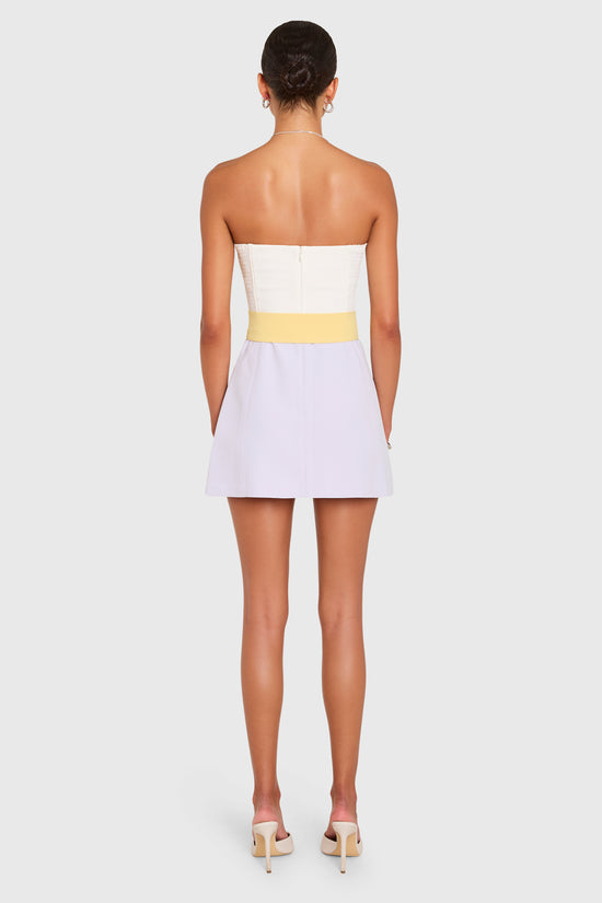 Amanda Uprichard |   Fae Romper in Ivory-Jasmiine-Daffodil. Model wears a color block mini dress against a white backgorund. view 3