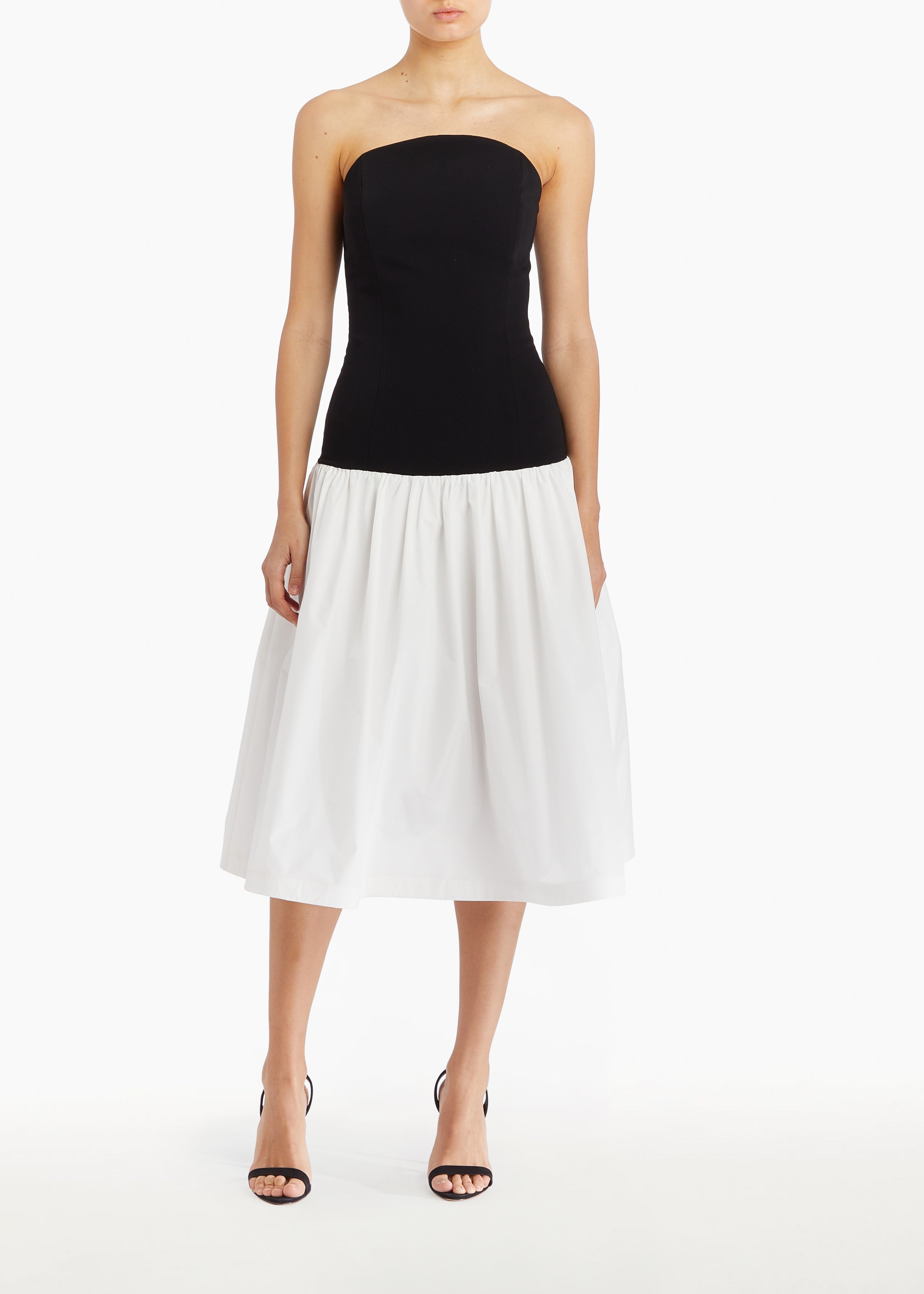 Model wearing a Black and white strapless dress on a white background