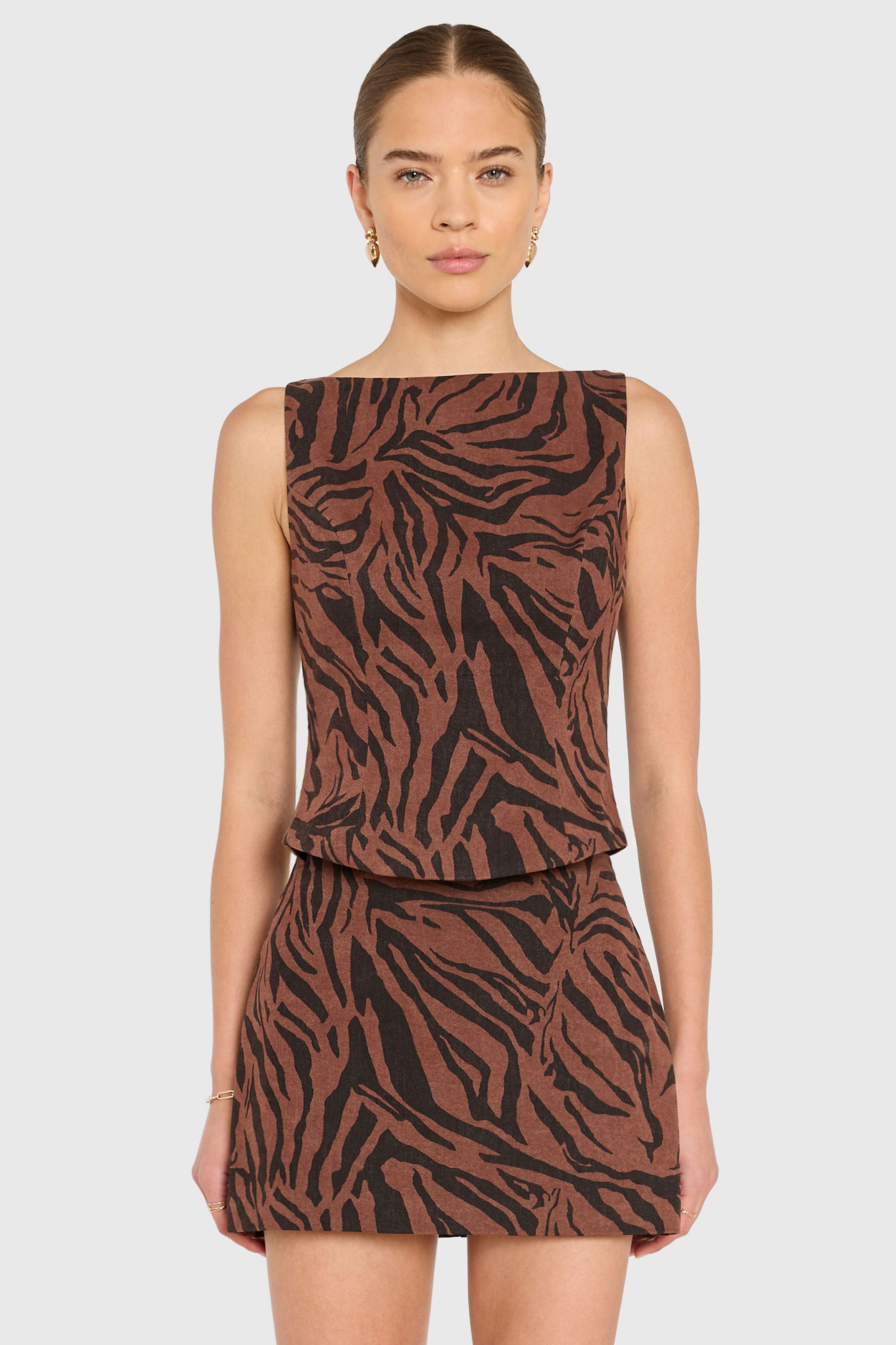 Woman wearing a brown and black zebra print dress on a white background