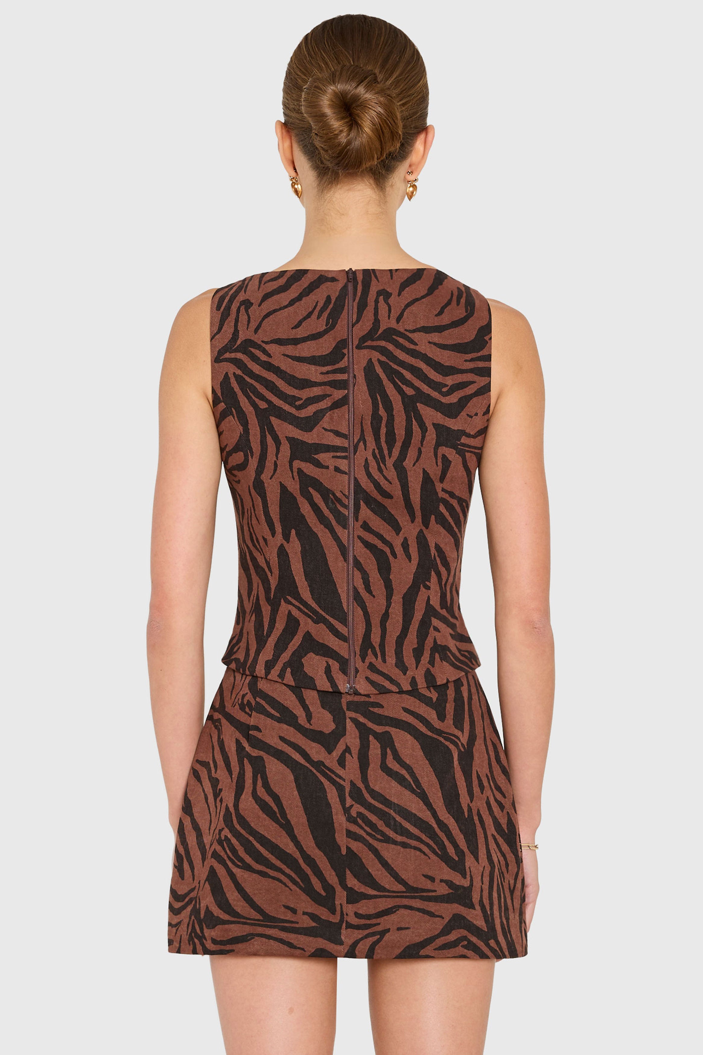 Woman wearing a brown and black zebra print dress on a white background