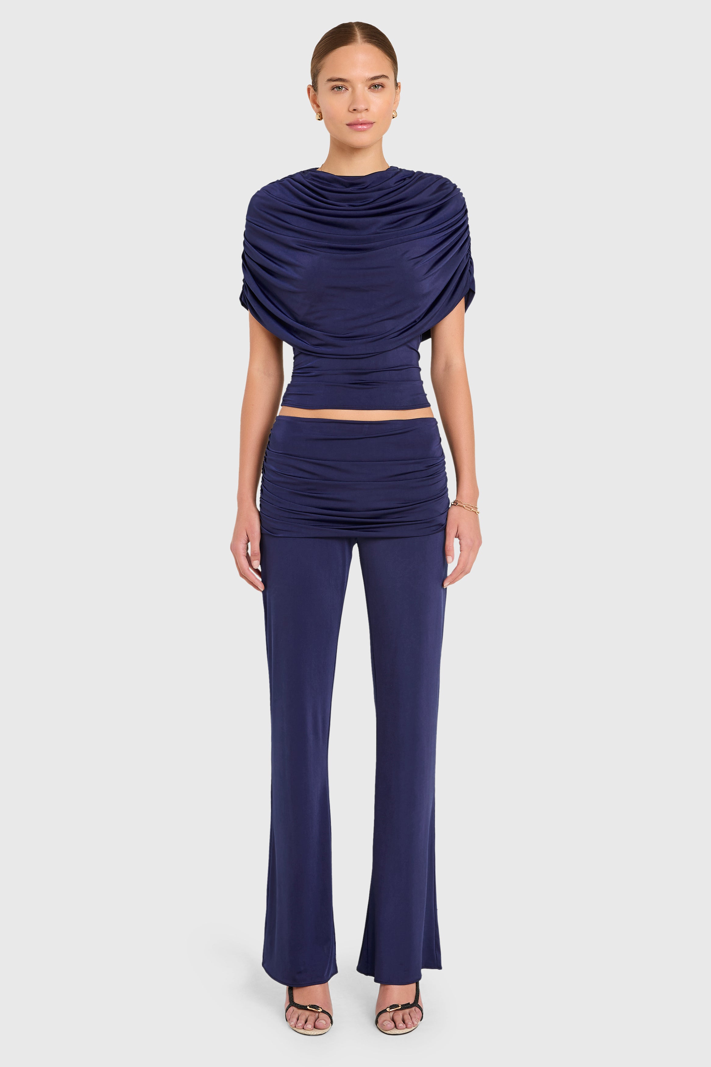 Amanda Uprichard |   Marcelle Top in Navy Blue. Model wears blue top against a white backgorund.