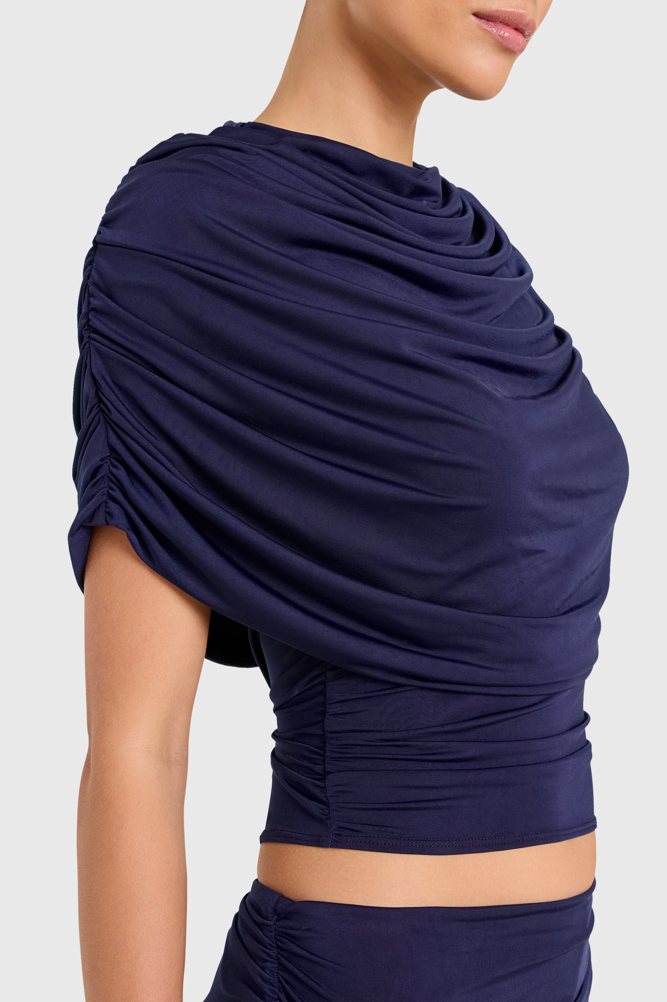 Amanda Uprichard |   Marcelle Top in Navy Blue. Model wears blue top against a white backgorund.