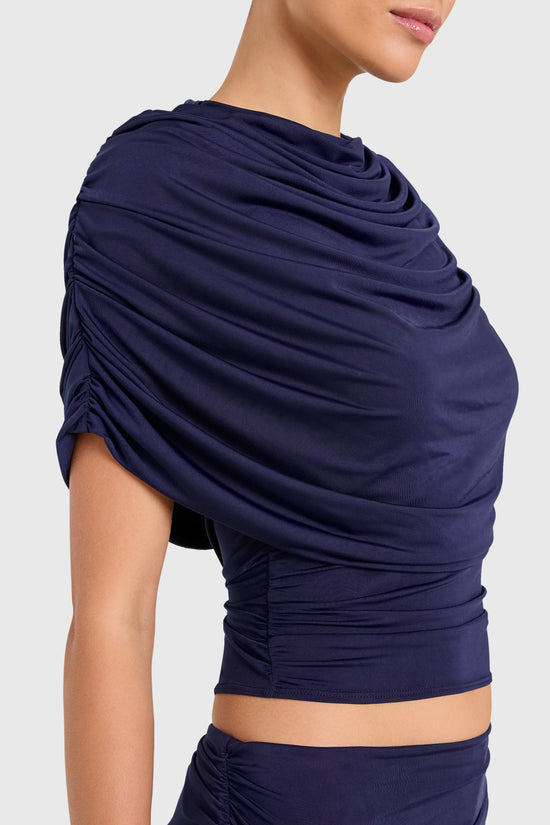Amanda Uprichard |   Marcelle Top in Navy Blue. Model wears blue top against a white backgorund. view 3
