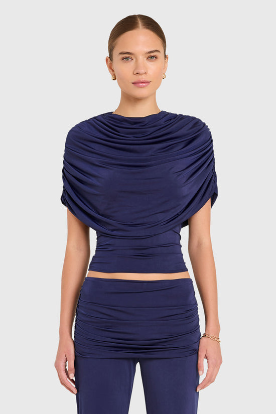 Amanda Uprichard |   Marcelle Top in Navy Blue. Model wears blue top against a white backgorund. view 2