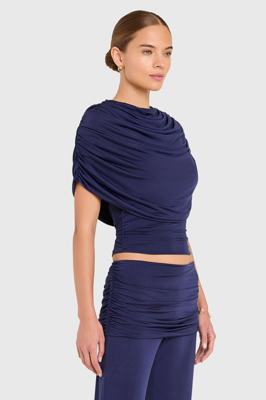 Amanda Uprichard |   Marcelle Top in Navy Blue. Model wears blue top against a white backgorund. view 3