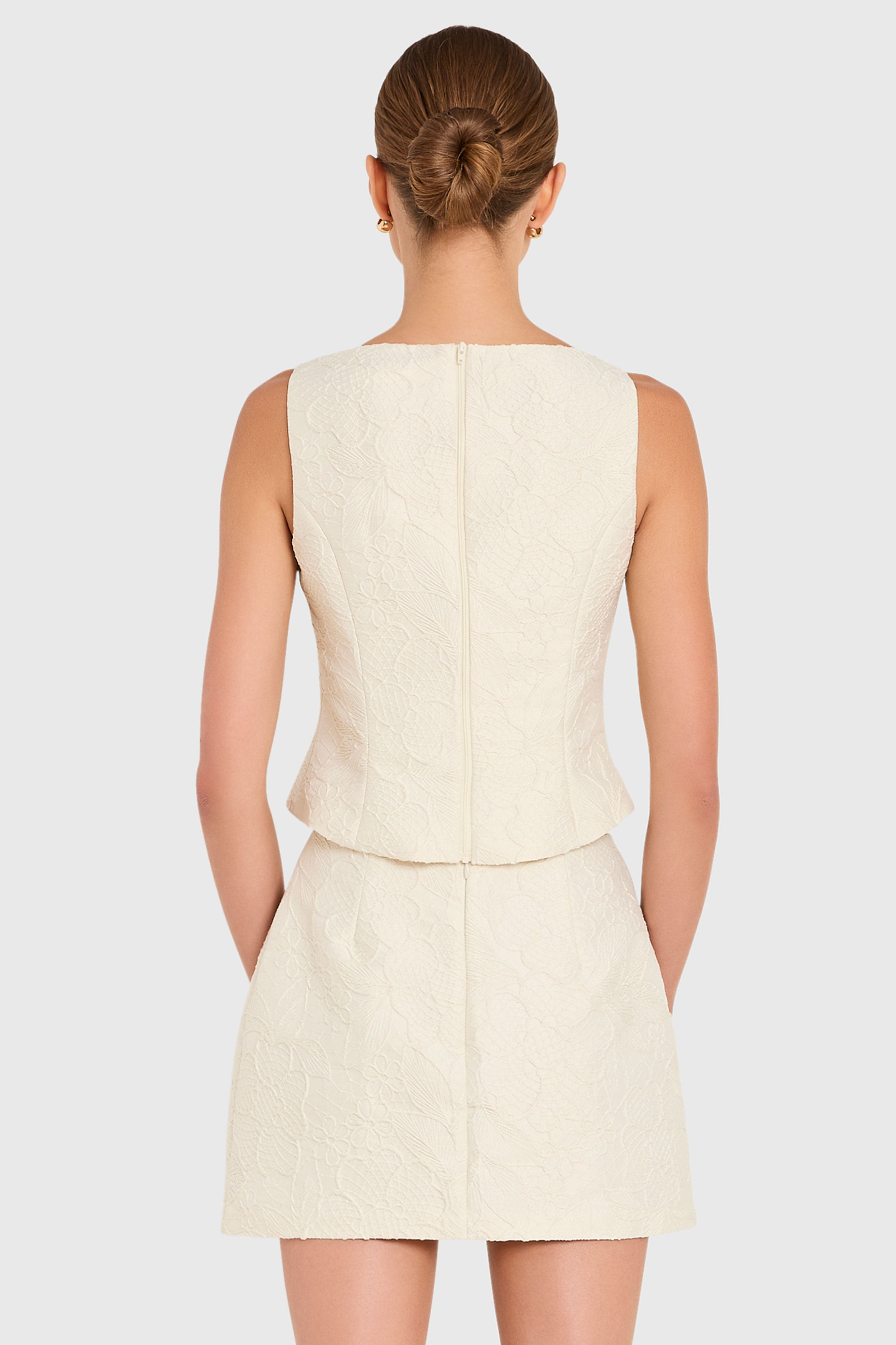 Amanda Uprichard |   Ines Top in Honeyblossom Brocade. Model wears a white sleeveless top against a white backgorund.