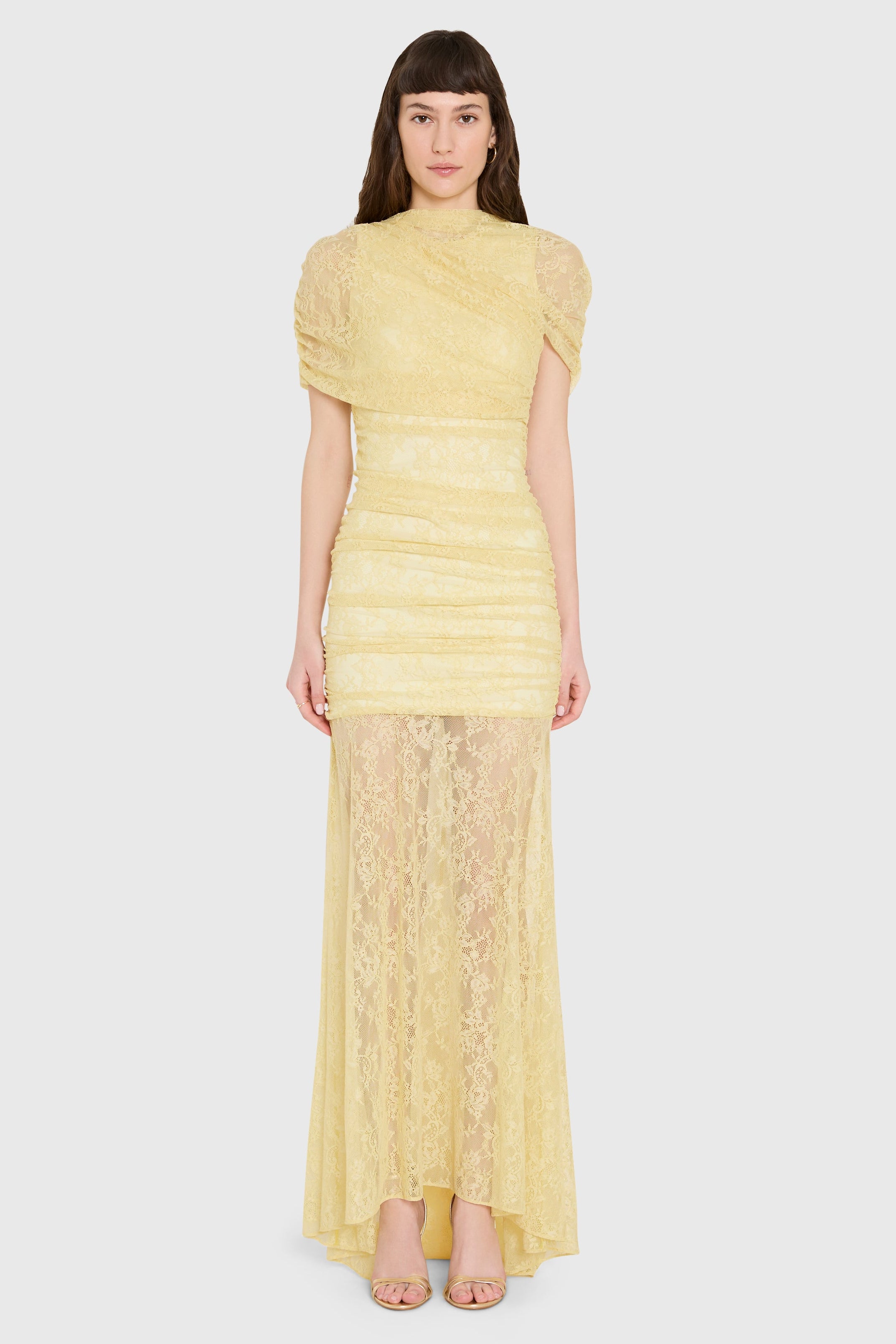Woman wearing a yellow lace dress on a white background