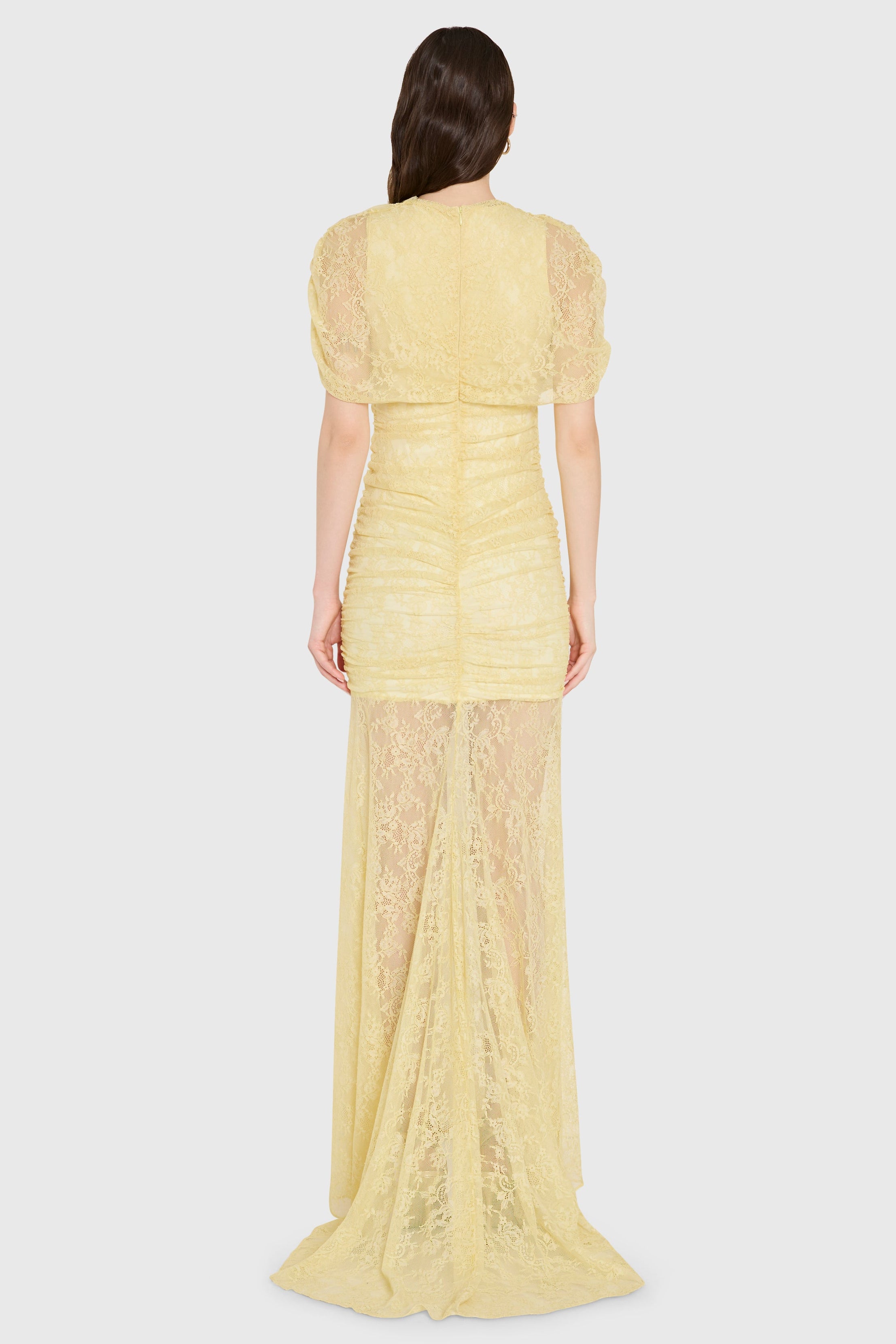 Woman wearing a yellow lace dress on a white background
