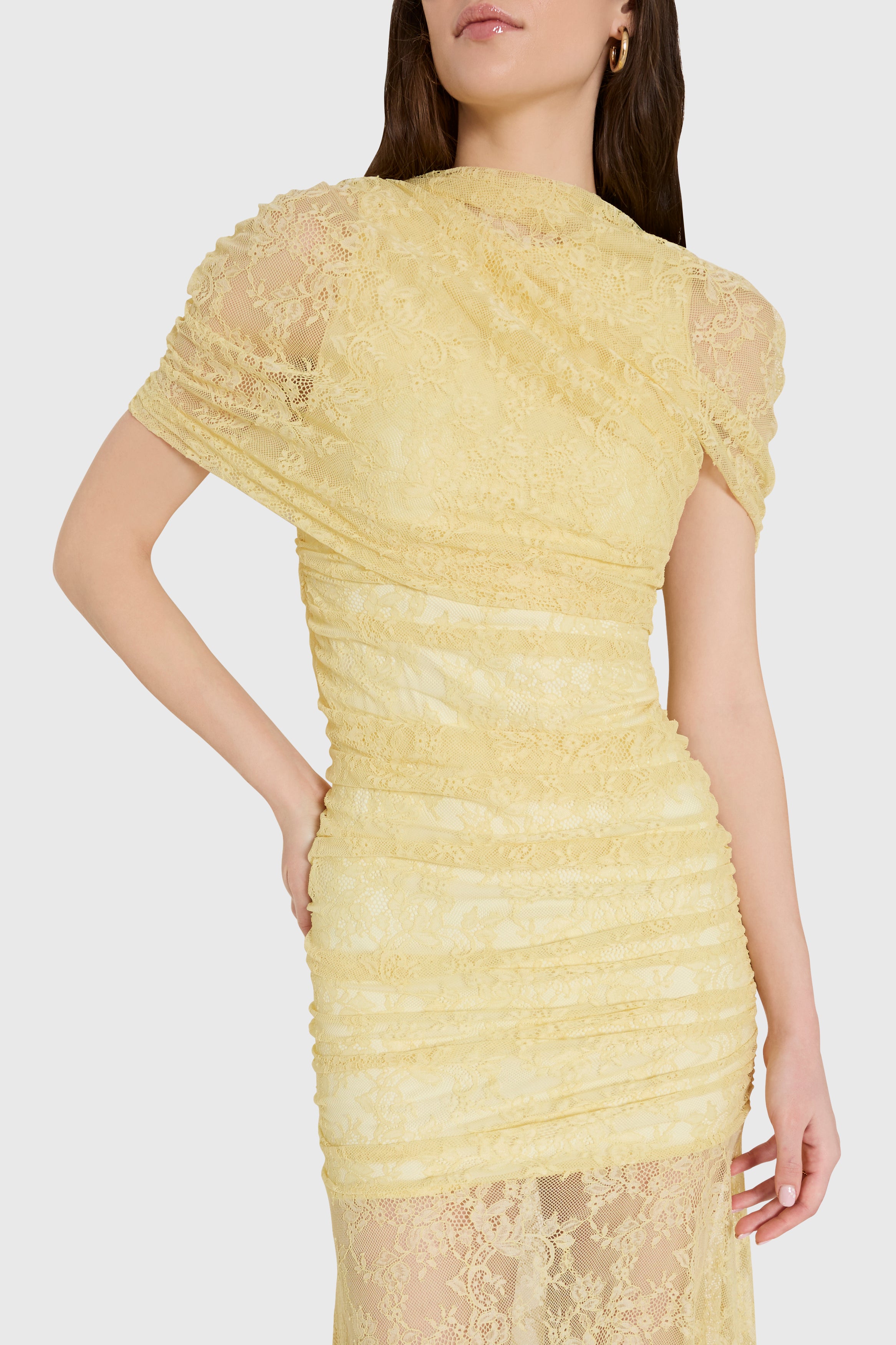 Yellow lace dress worn by a model on a white background