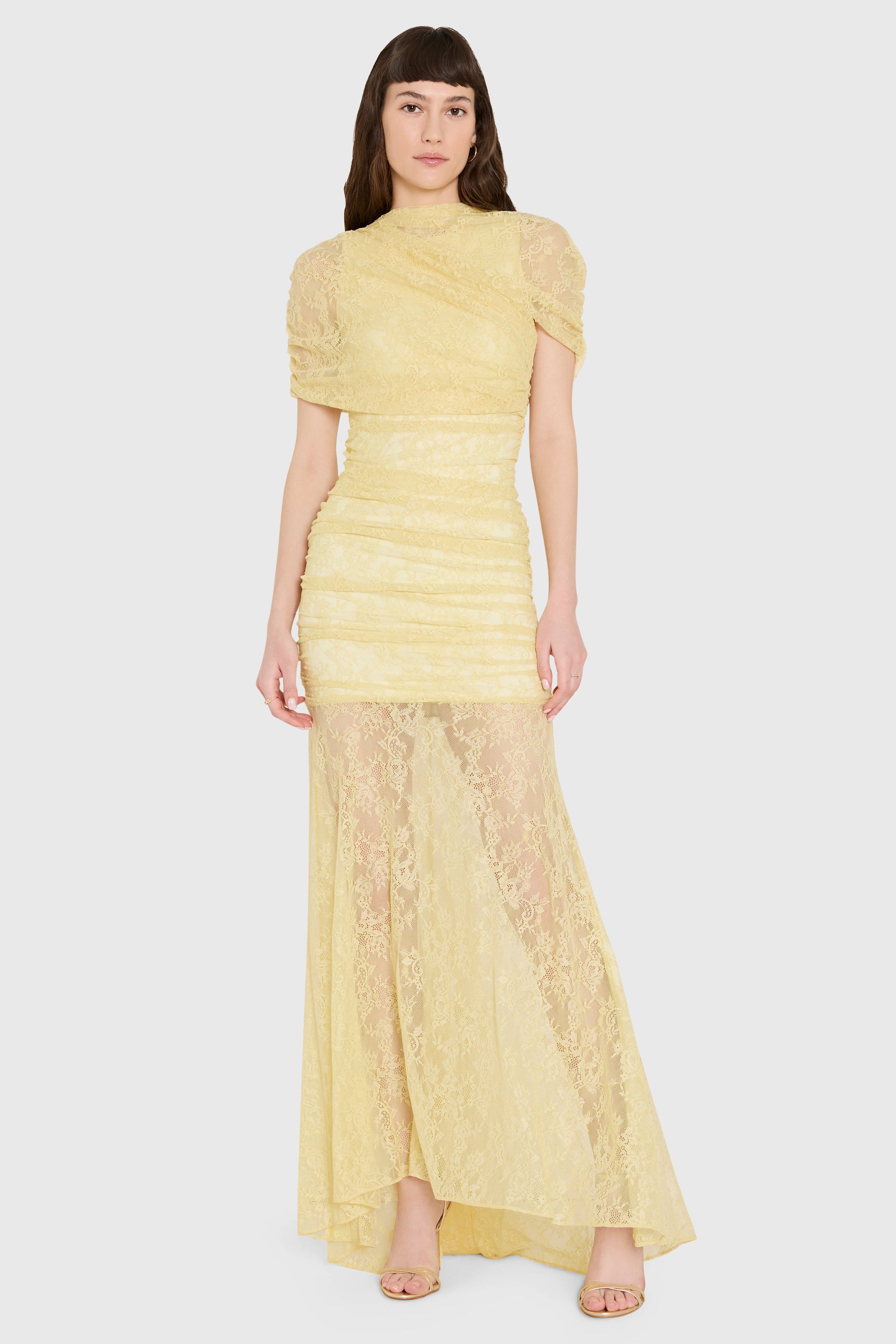 Woman wearing a yellow lace dress on a white background