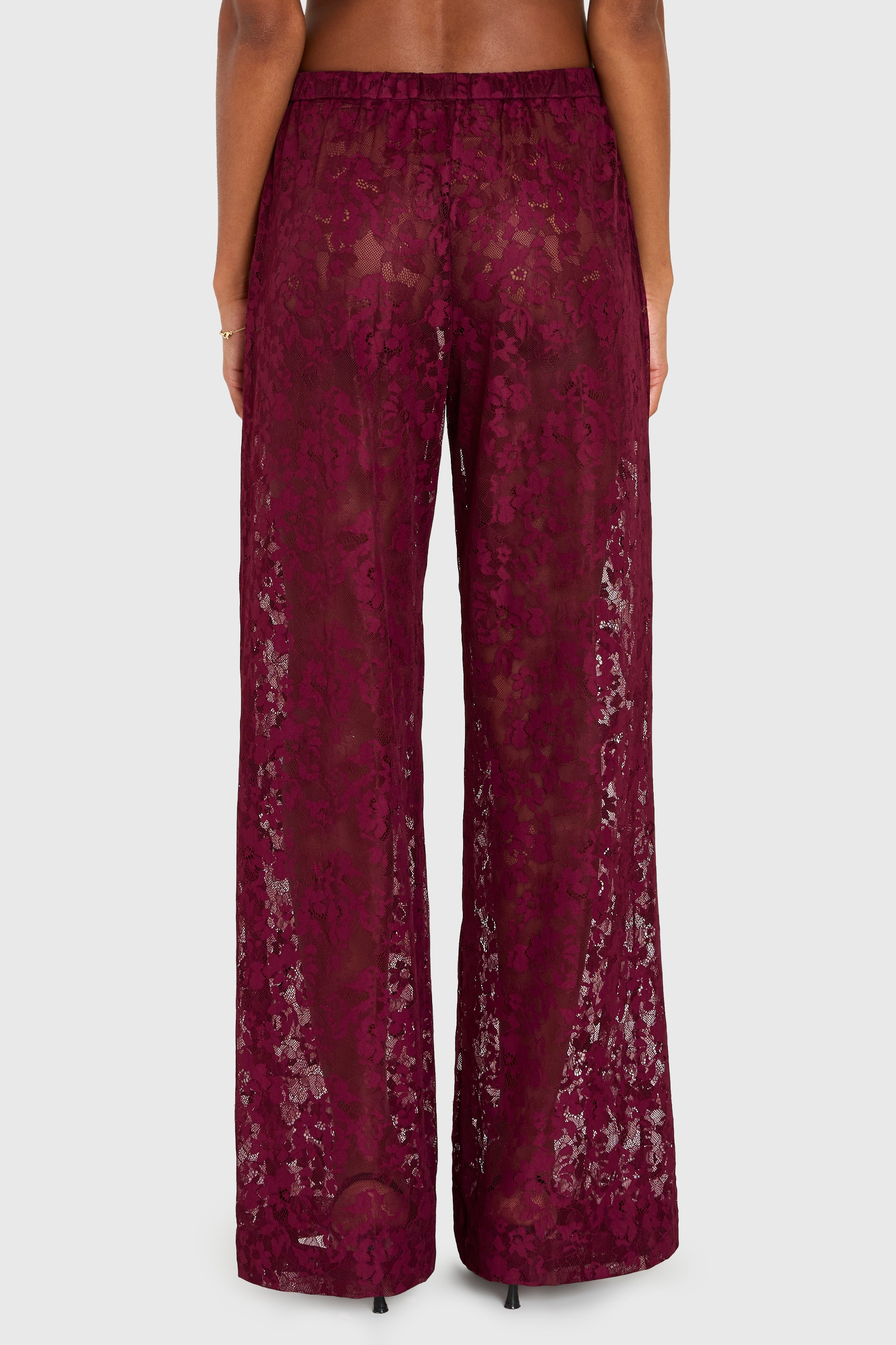 Maroon lace pants on a white background