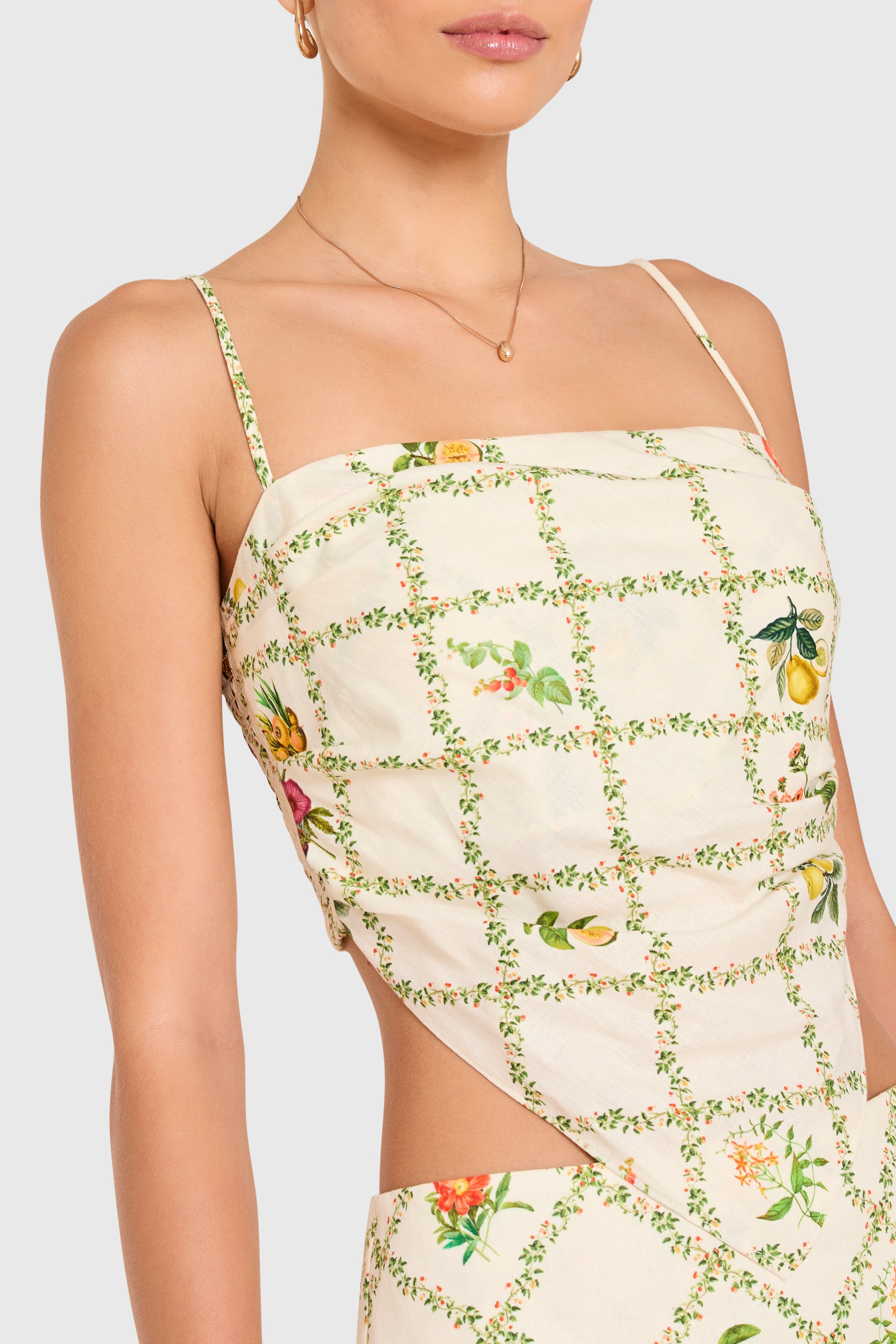 Amanda Uprichard | Juna Top in Trellis. Model wears a mini floral print top against a white backgorund.