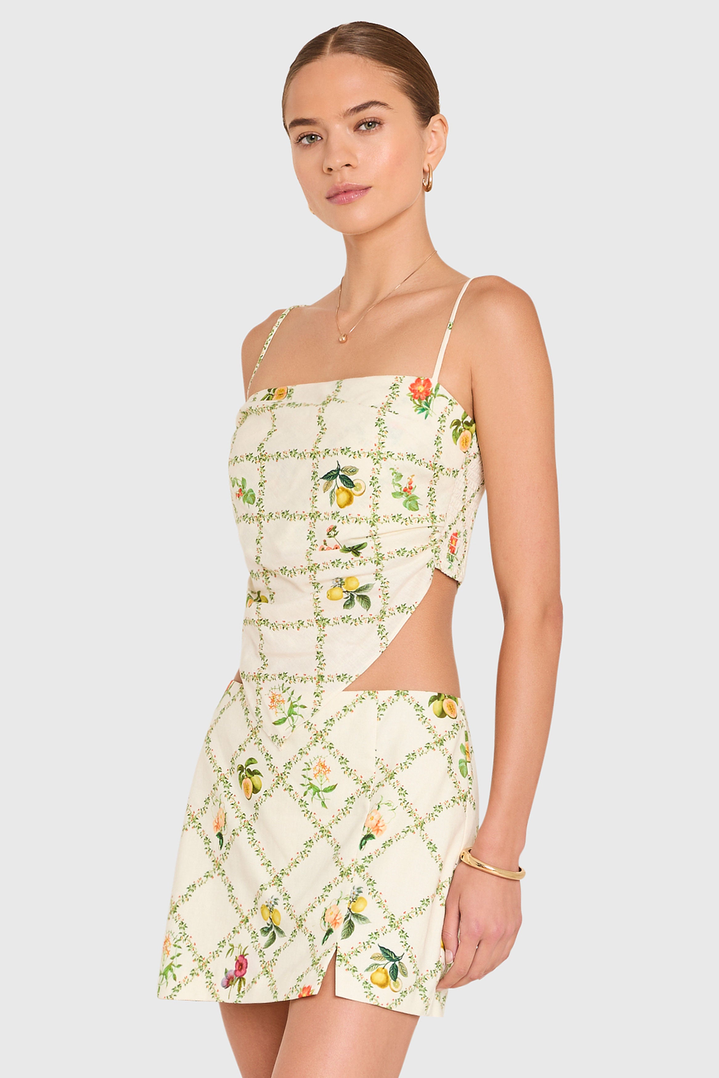 Amanda Uprichard | Juna Top in Trellis. Model wears a mini floral print top against a white backgorund.