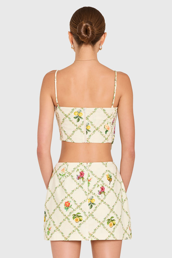 Amanda Uprichard | Juna Top in Trellis. Model wears a mini floral print top against a white backgorund. view 3