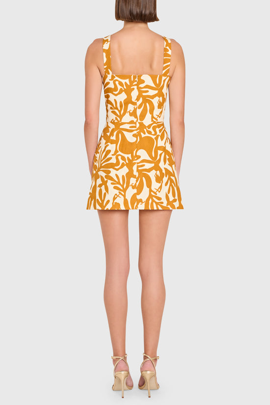 Woman wearing a yellow patterned dress on a white background