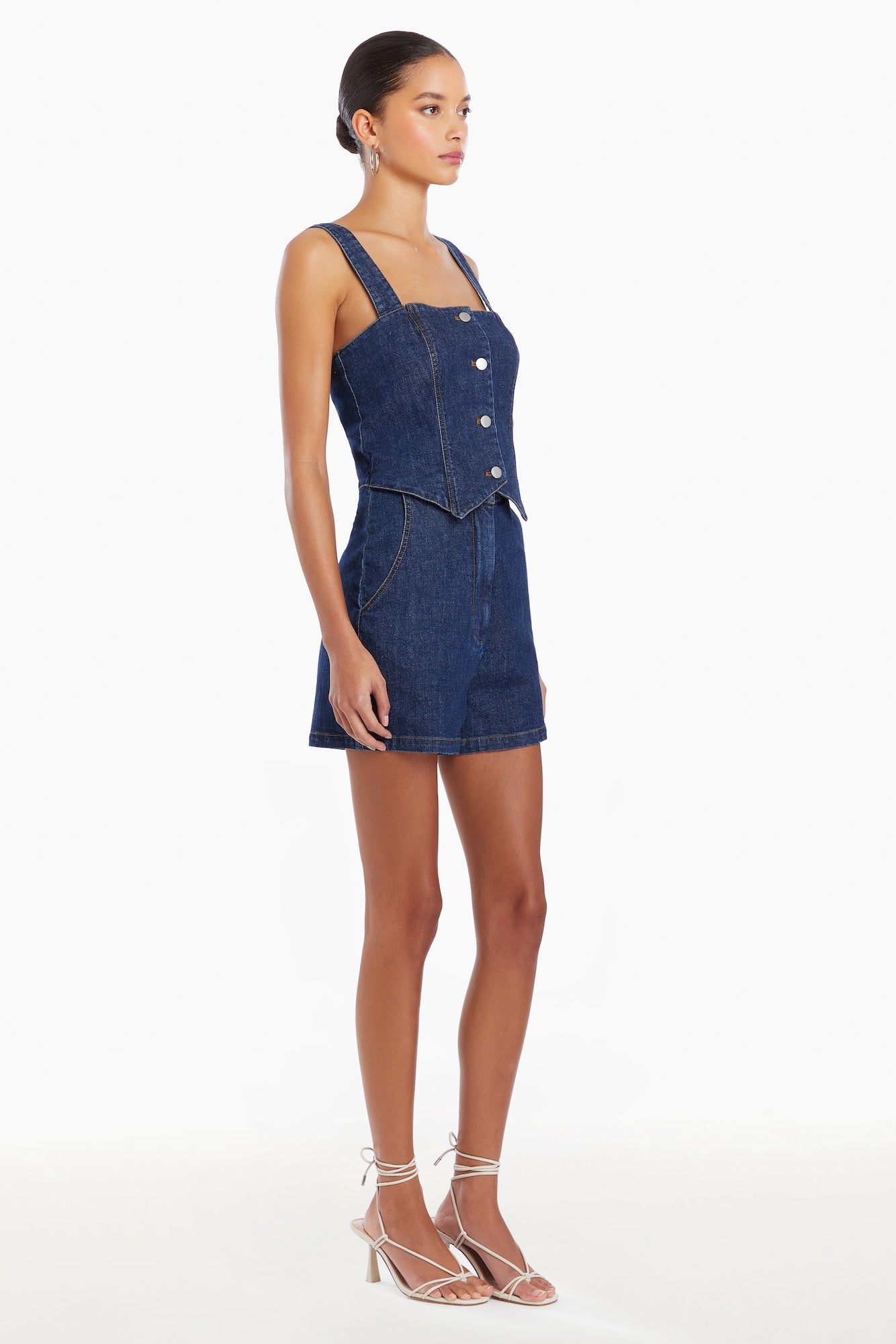 Girl in denim romper, side facing.