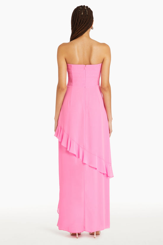 Girl in pink ruffle maxi dress with slit, back facing.