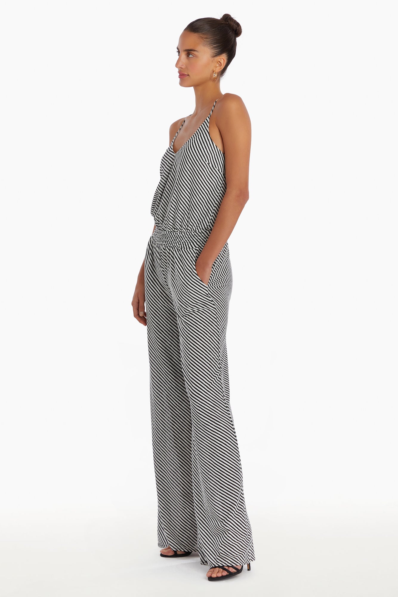 Girl in striped jumpsuit, side facing.