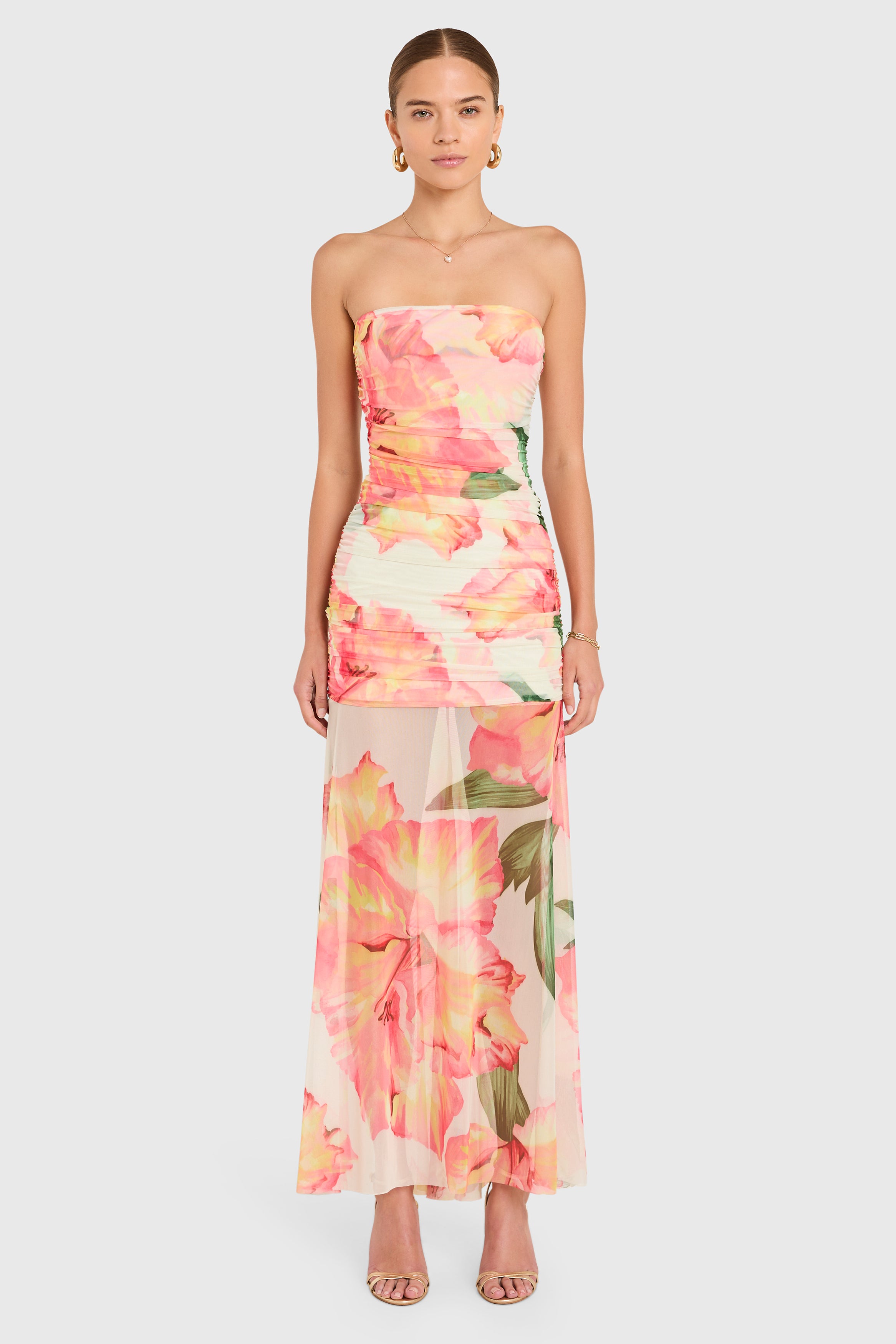 Amanda Uprichard |   Leo Maxi Dress in Hibiscus Print. Model wears a full length strapless floral dress against a white backgorund.